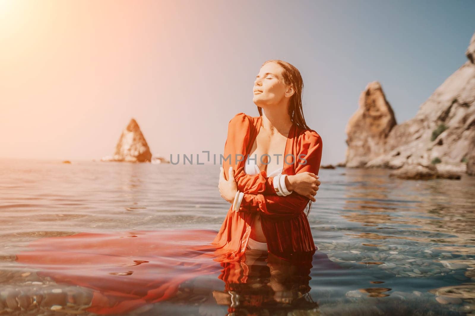 Woman travel sea. Happy tourist taking picture outdoors for memories. Woman traveler looks at the edge of the cliff on the sea bay of mountains, sharing travel adventure journey.