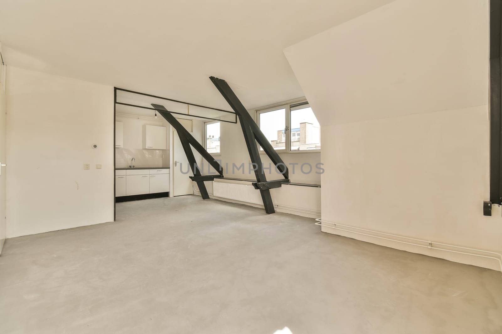 an empty living room with white walls and floor to ceiling windows looking out onto the street in front of it