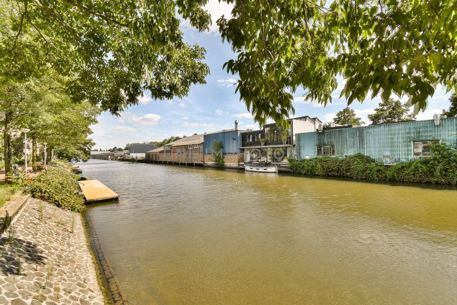 a river with houses on the side of it by casamedia