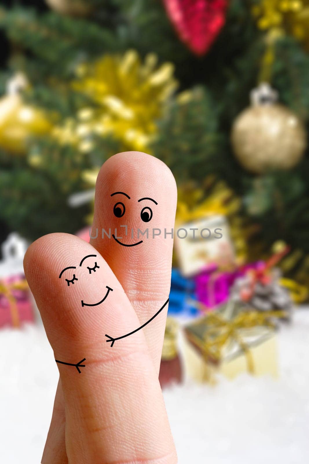 Faces of fingers hugging each other isolated on Christmas decorated background. Happy family celebrating Christmas day concept by Sonat