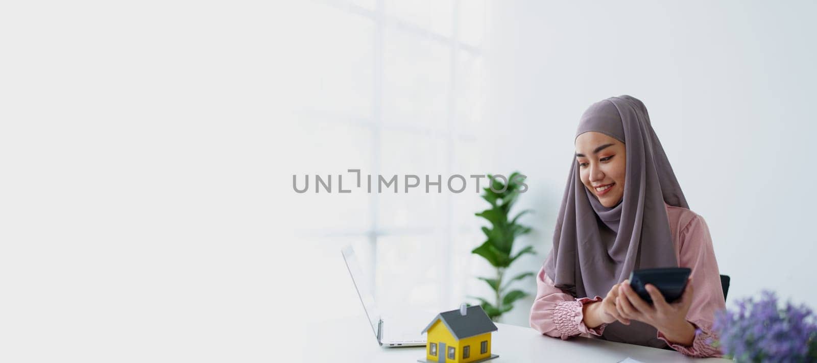 muslim woman with hijab using calculator focus on utility bills calculate check credit card receipt monthly expense. by Manastrong