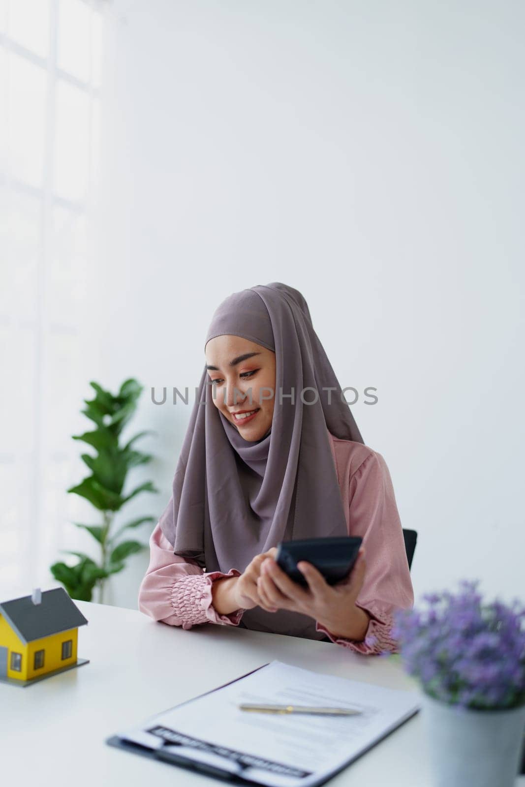 muslim woman with hijab using calculator focus on utility bills calculate check credit card receipt monthly expense. by Manastrong