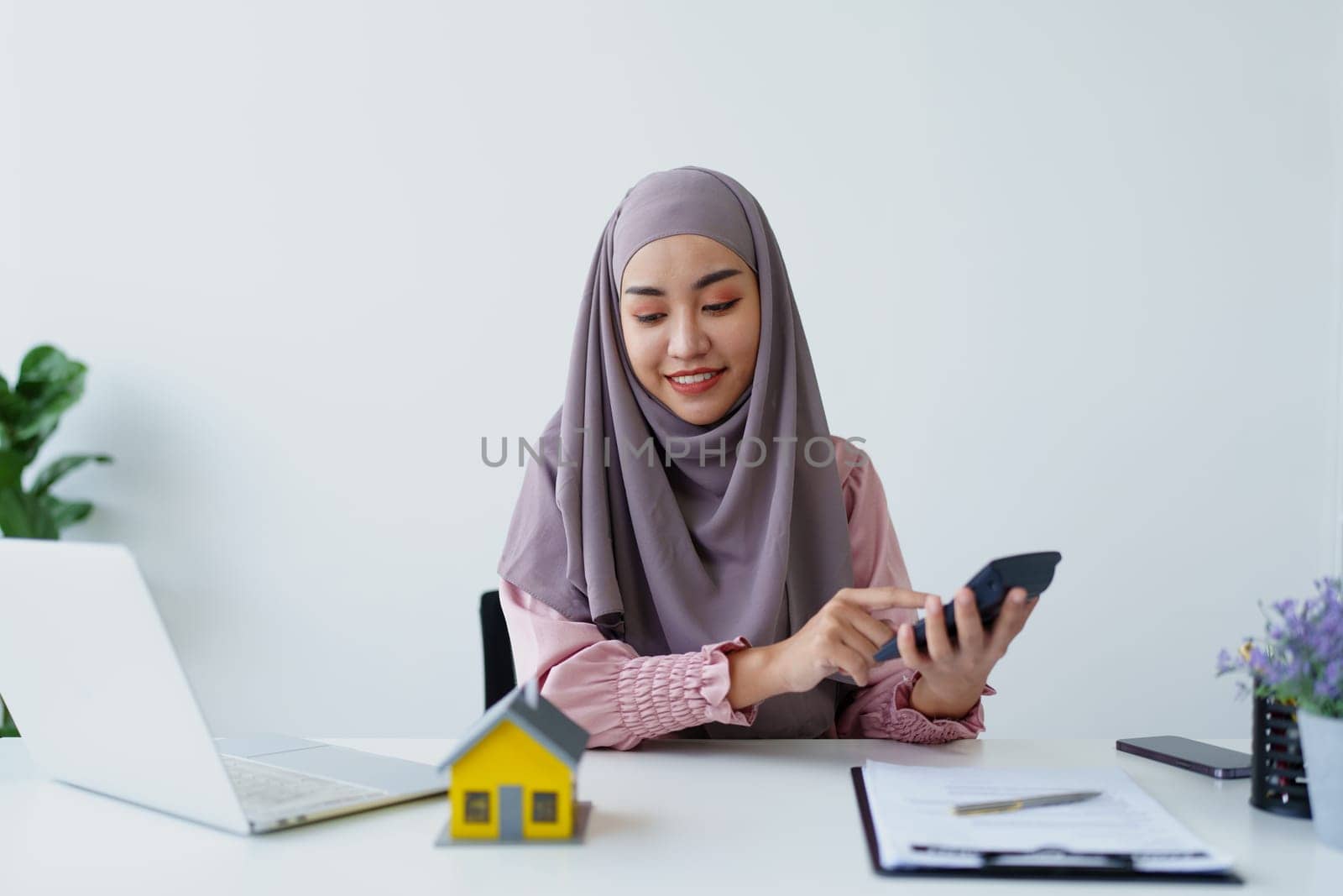 muslim woman with hijab using calculator focus on utility bills calculate check credit card receipt monthly expense