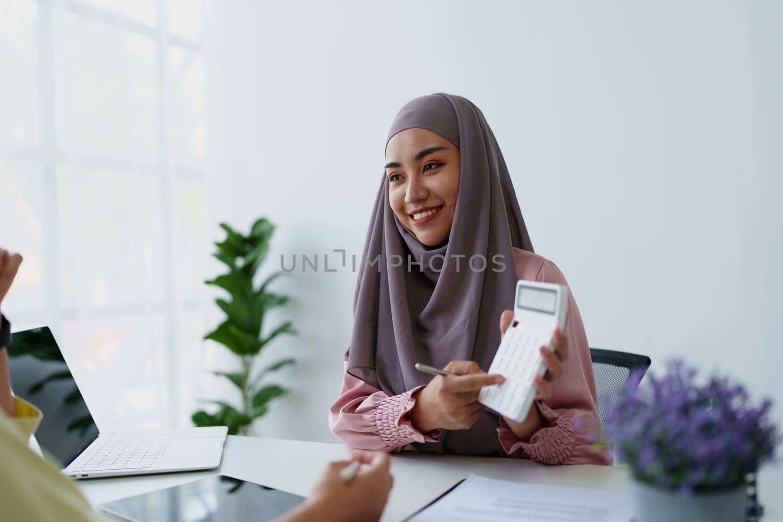 A female Muslim bank employee, making an agreement on a residential loan with a customer