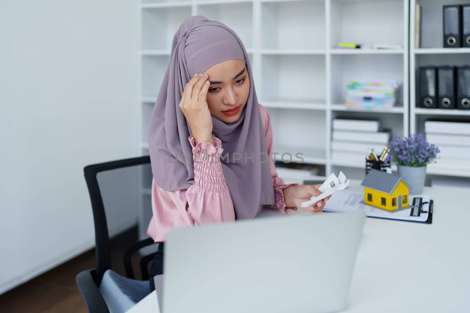 muslim woman with hijab using calculator focus on utility bills calculate check credit card receipt monthly expense