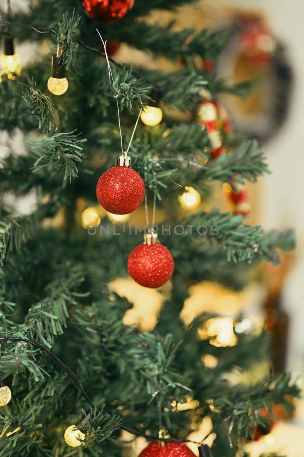 Glitter ornaments and lights on Christmas tree branch decorated. Christmas holiday and New Year concept.