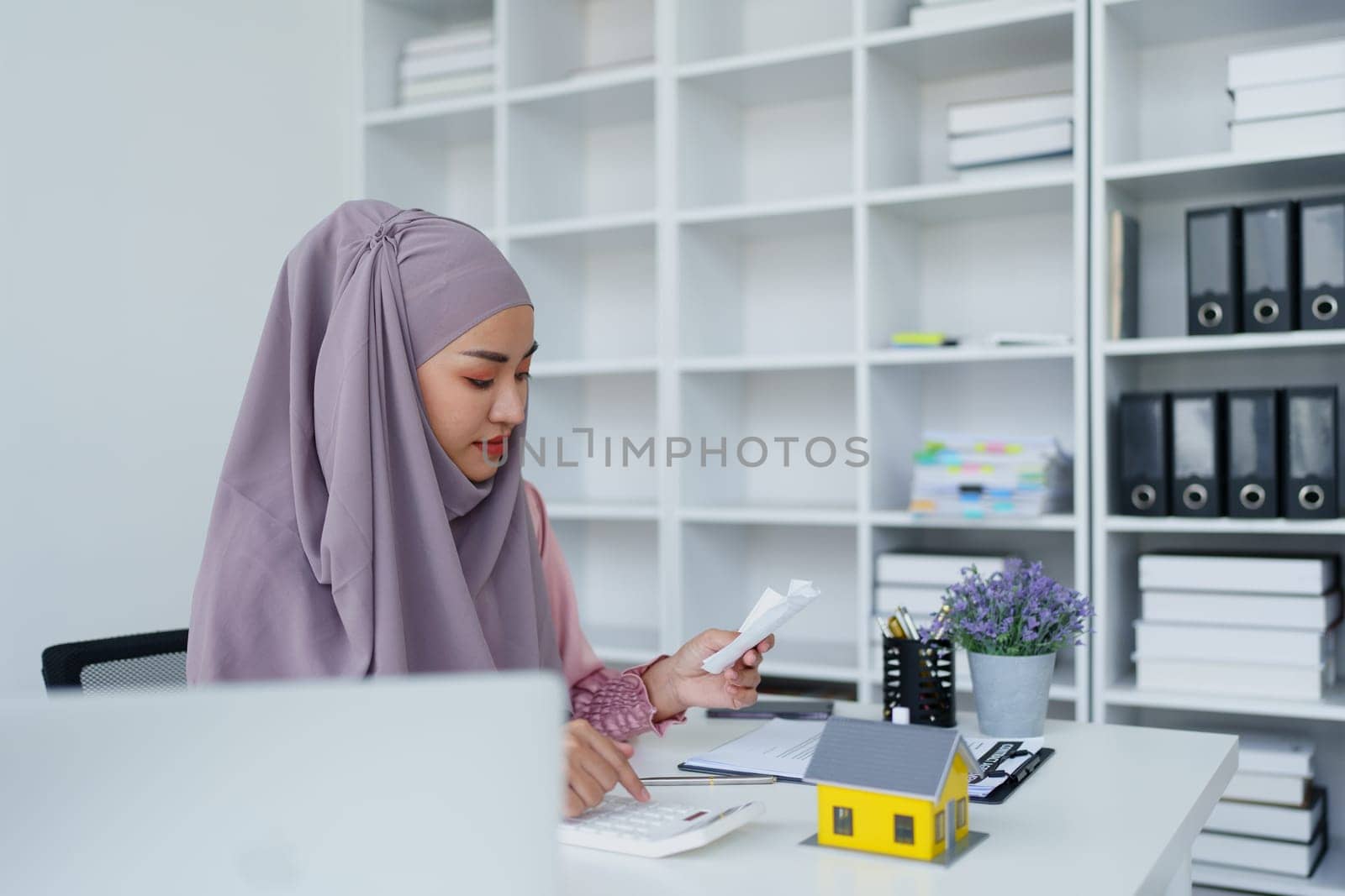 muslim woman with hijab using calculator focus on utility bills calculate check credit card receipt monthly expense