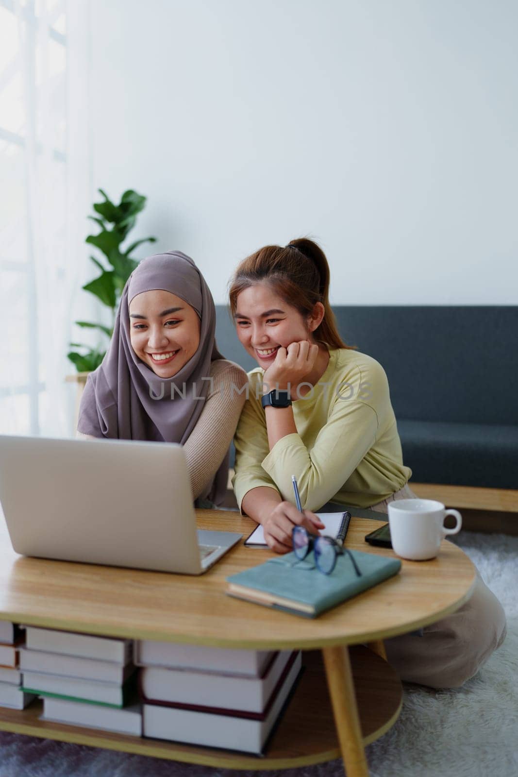 Muslim undergraduates and Asian women are studying online using computers. by Manastrong