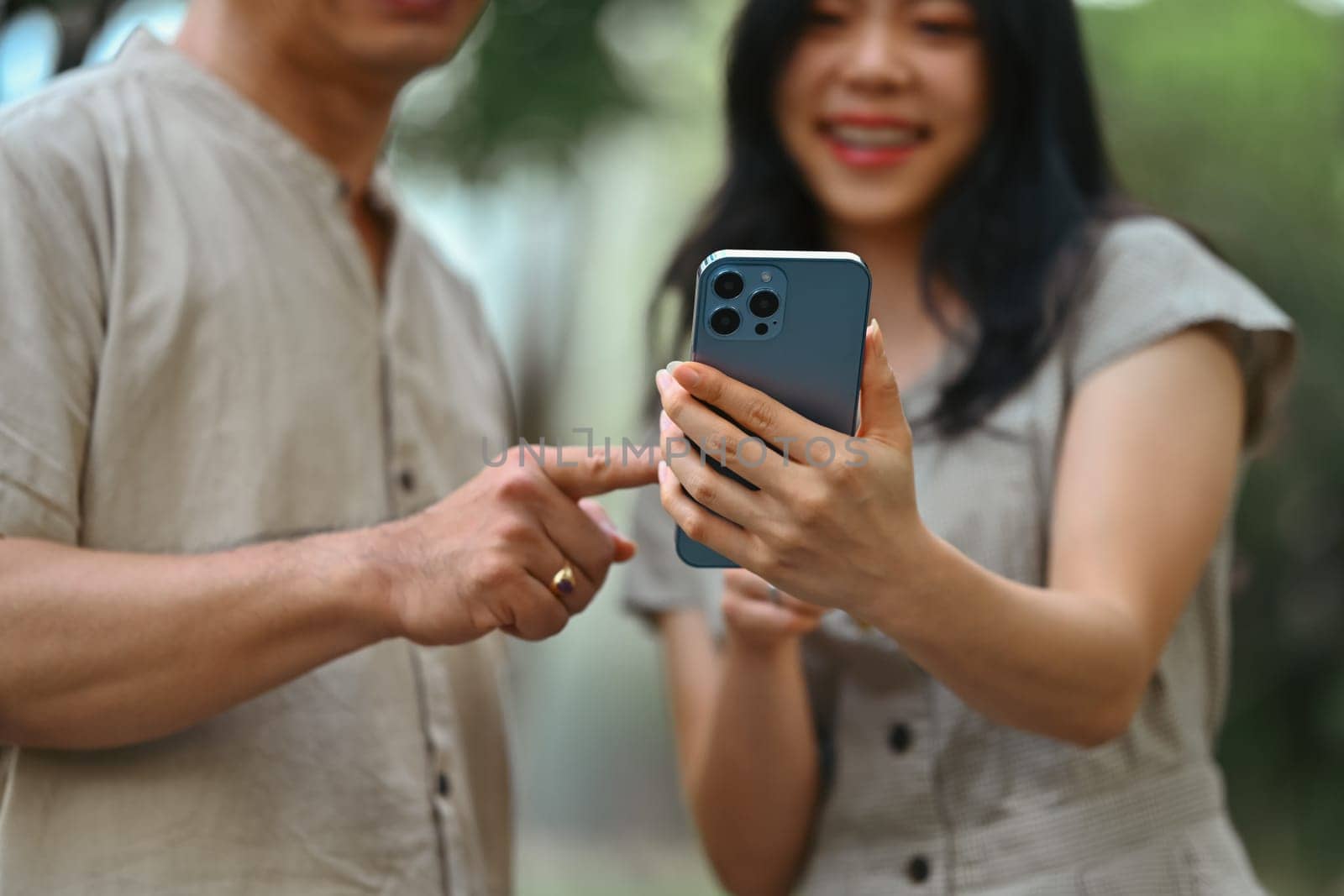 Cheerful young woman and father watching video content online on mobile phone.