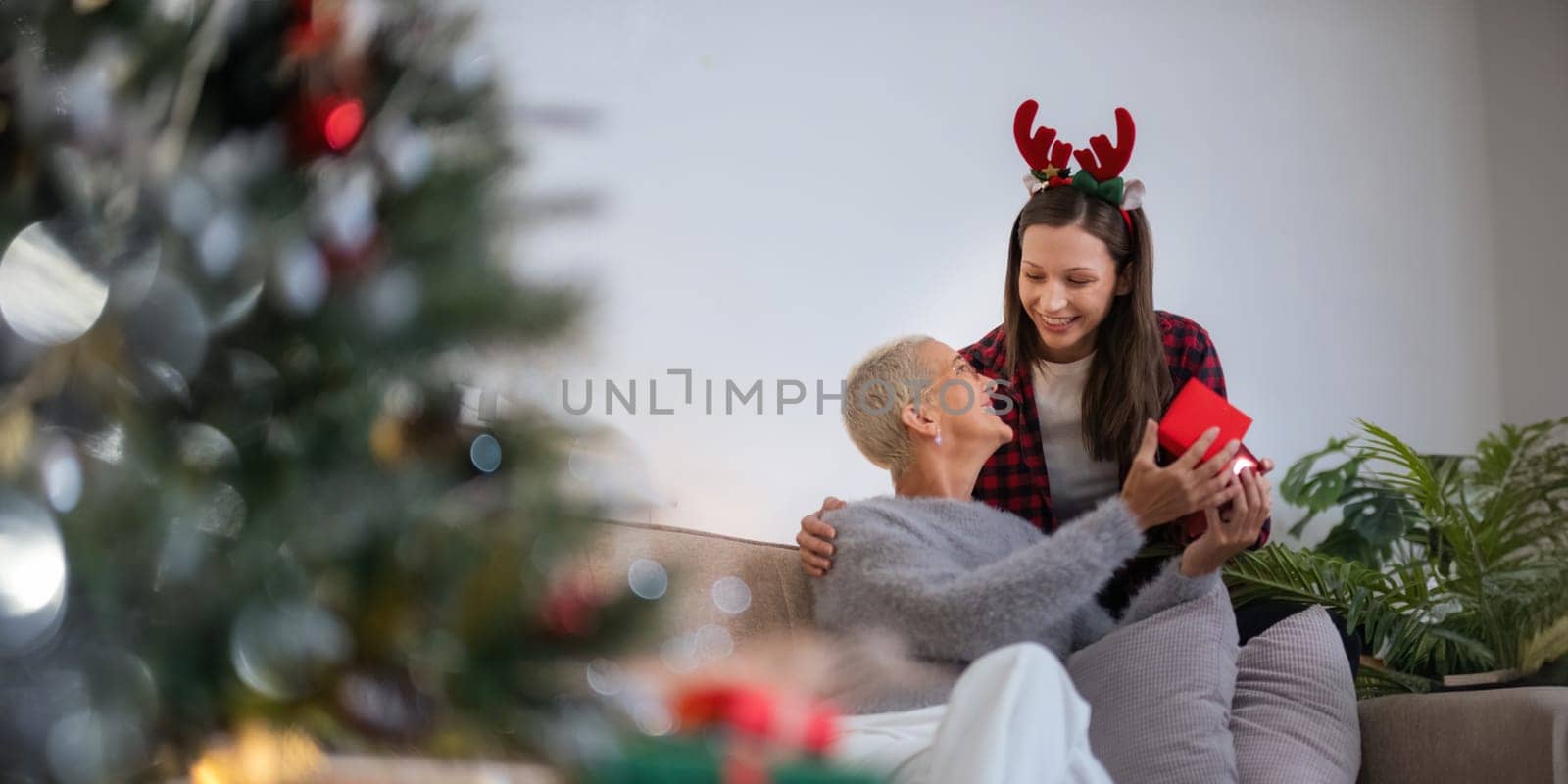 Caucasian Family, winter holiday and concept happy mother and daughter decorating christmas tree and give a gift at home.