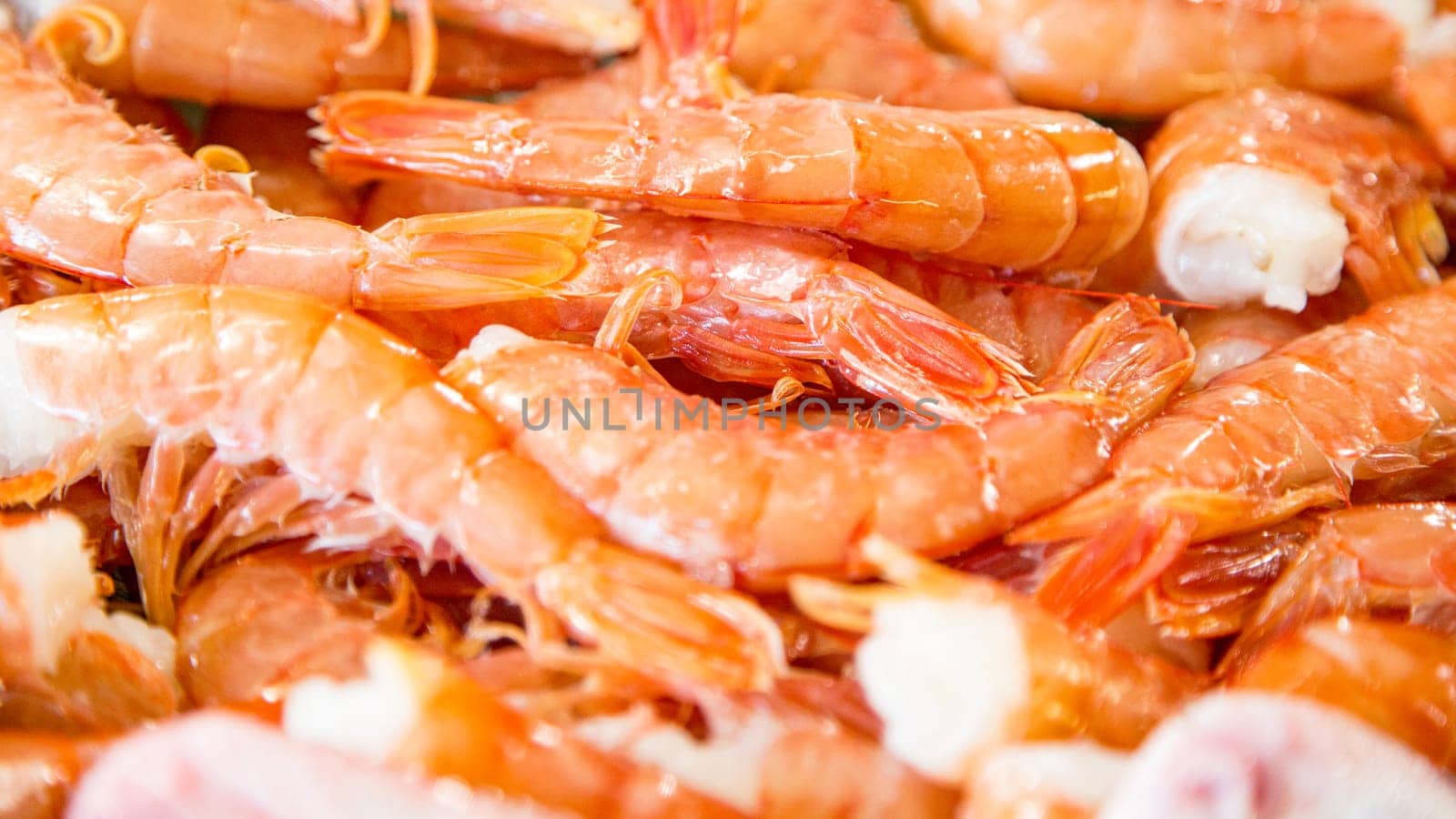 Top view of small red fresh prawns on a fishmonger's stall. Gourmet sea healthy food.