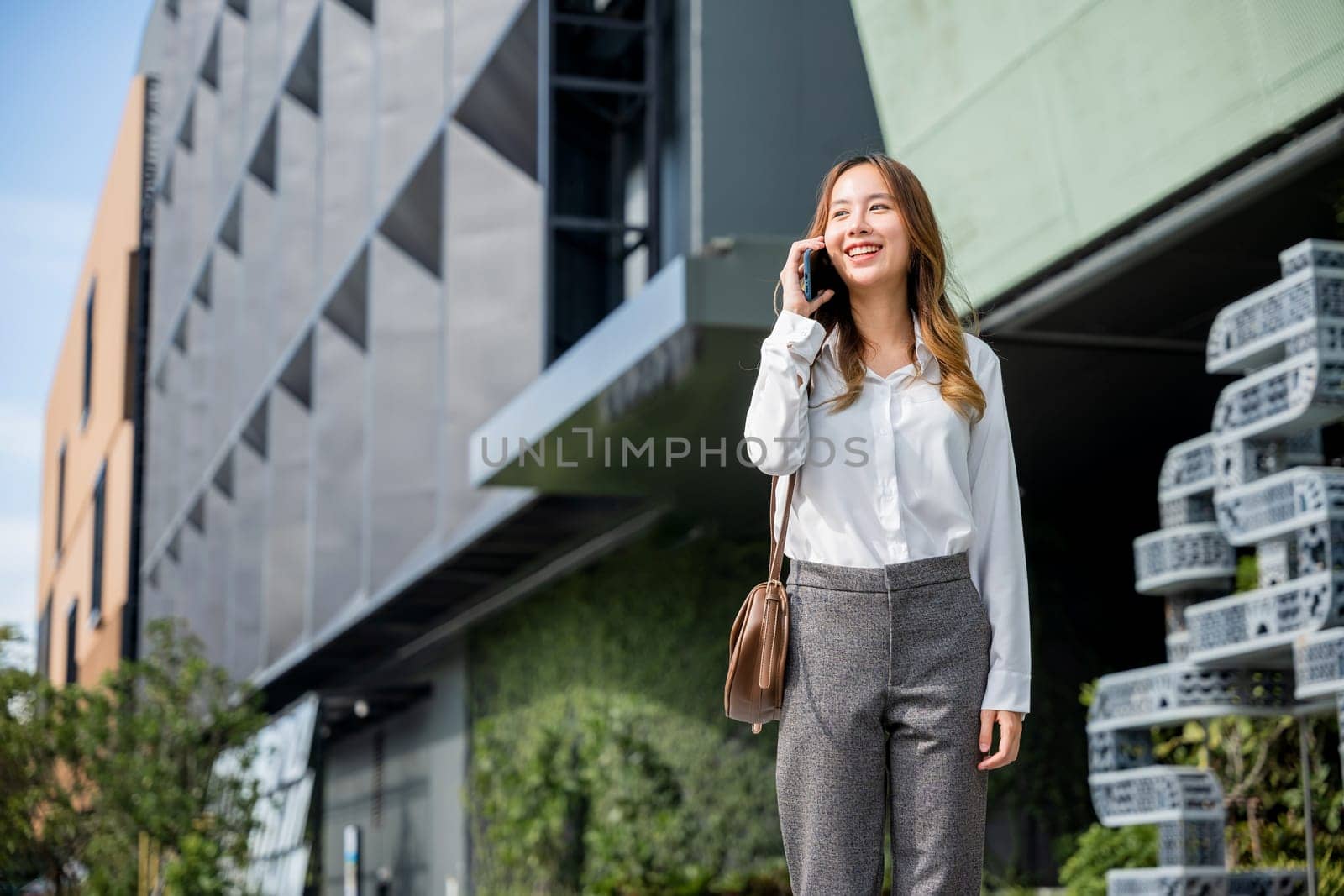 Young lawyer business woman walking street outdoor calling and talking on mobile phone with client, happy people smile talk on smartphone, cellphone communication