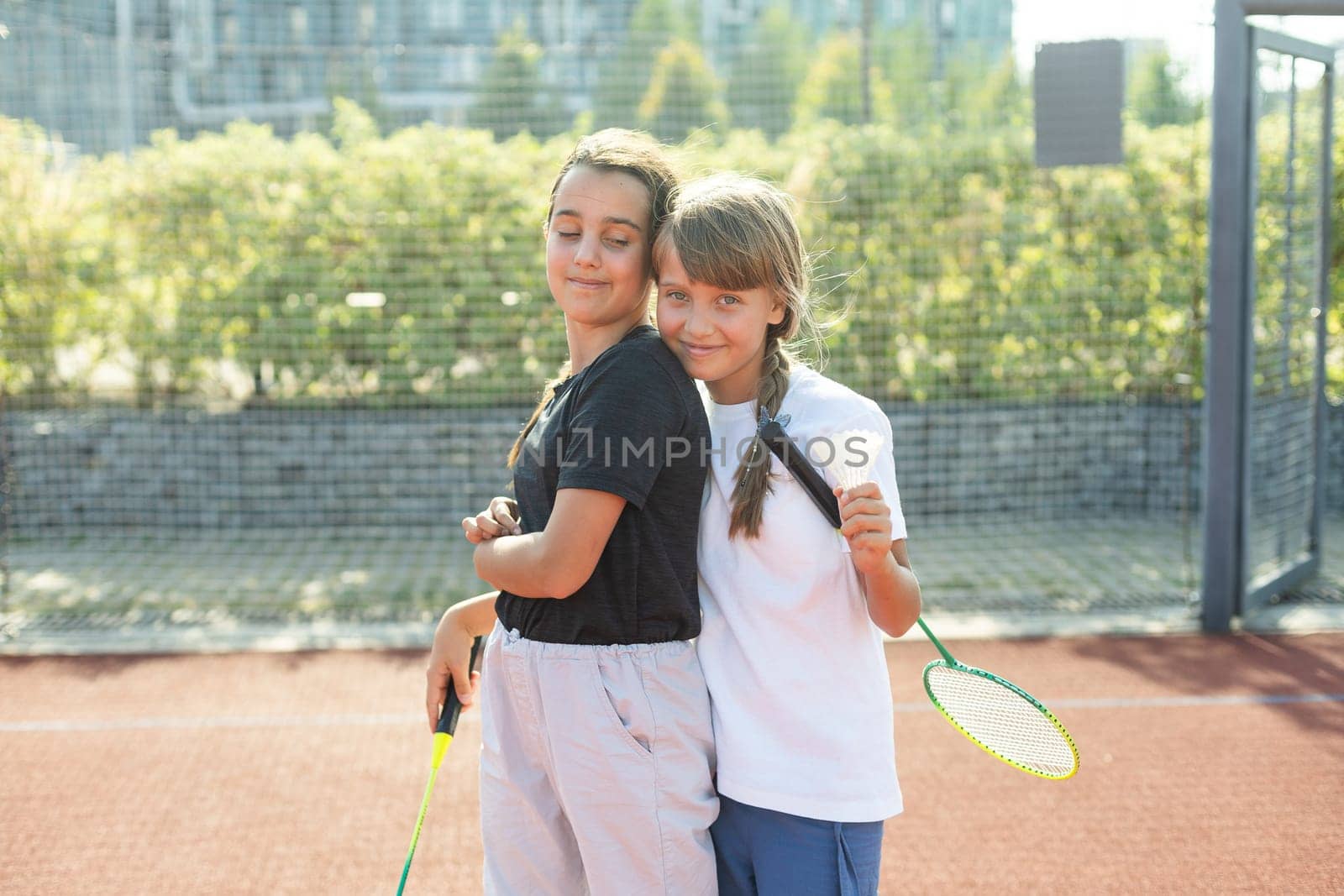 Two girls with badminton rackets on the football field. High quality photo