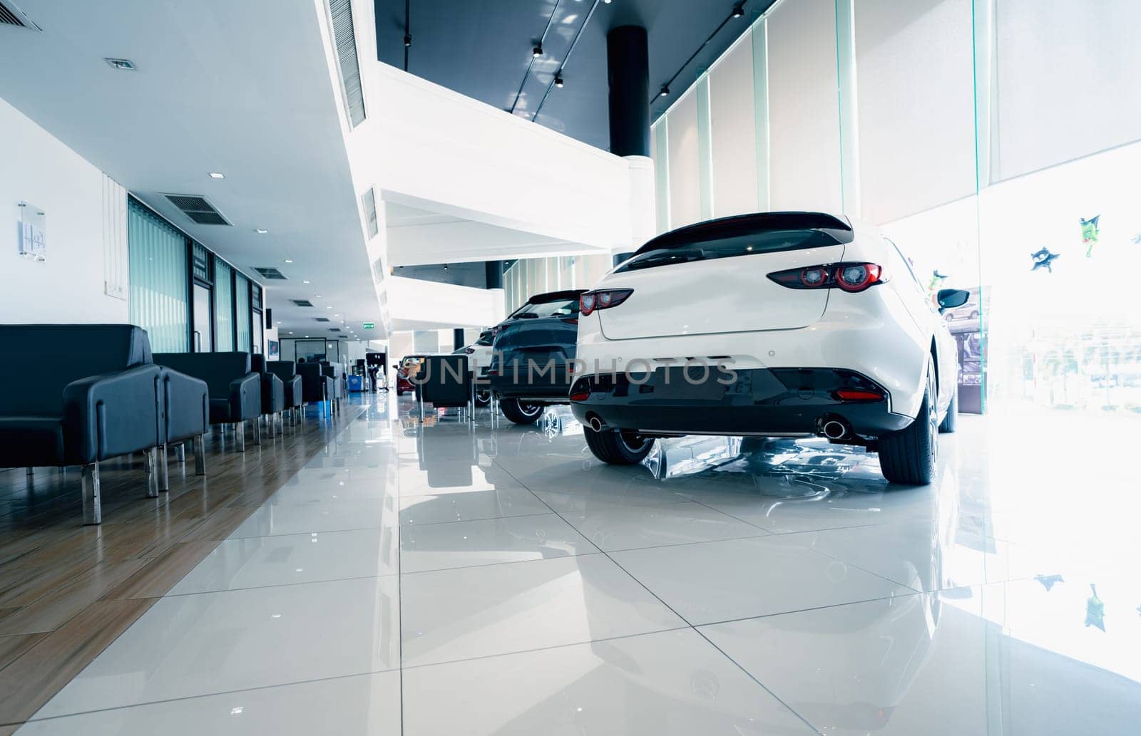 Rearview car parked in luxury showroom. Car dealership office. New car parked in modern showroom. Car for sale and rent business concept. Automobile leasing and insurance concept. Electric automobile. by Fahroni