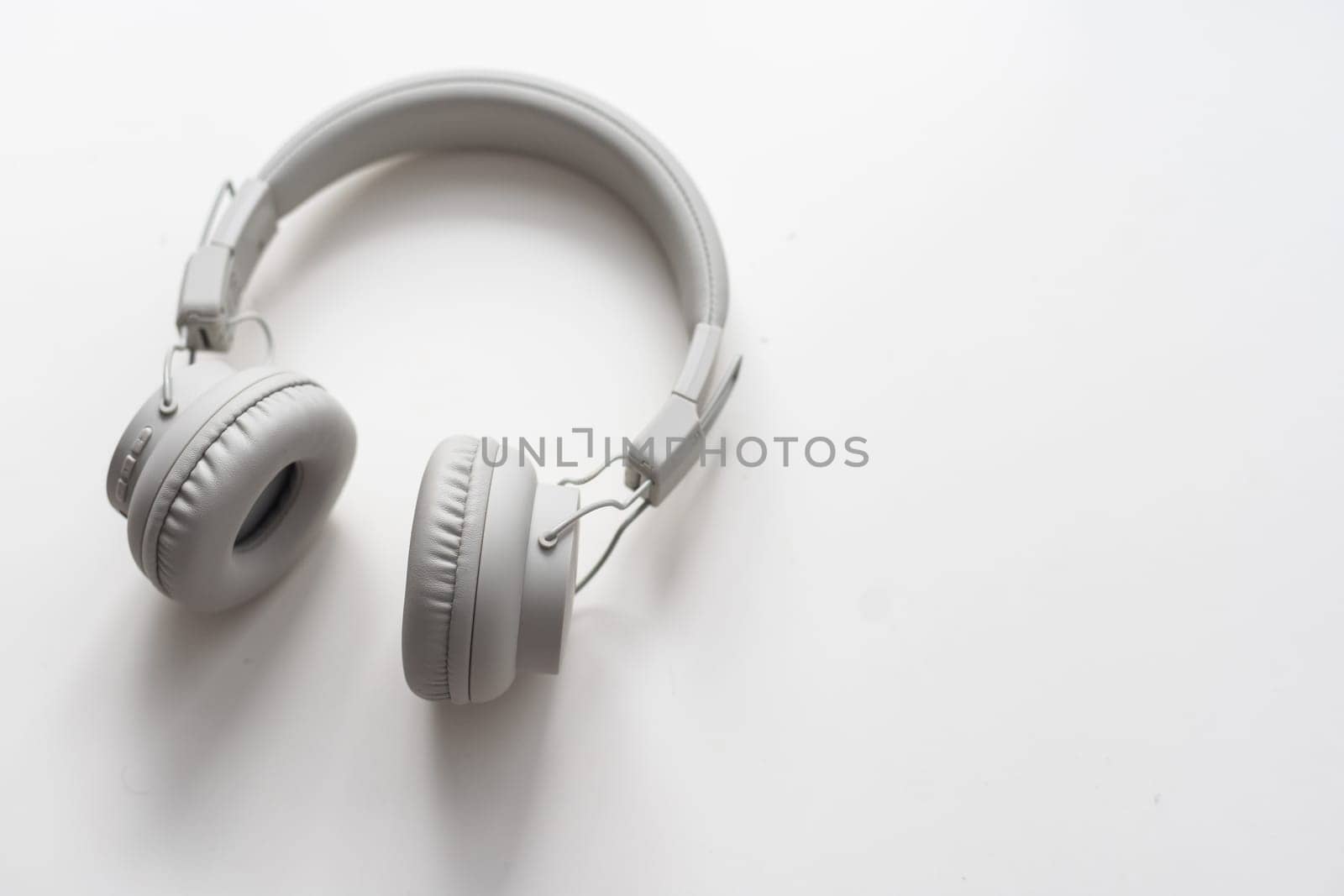 Gray wireless headphones on white background isolated close up, grey headset with big leather ear pad cushions design, modern black wi-fi stereo sound earphones side view, audio music device. High quality photo