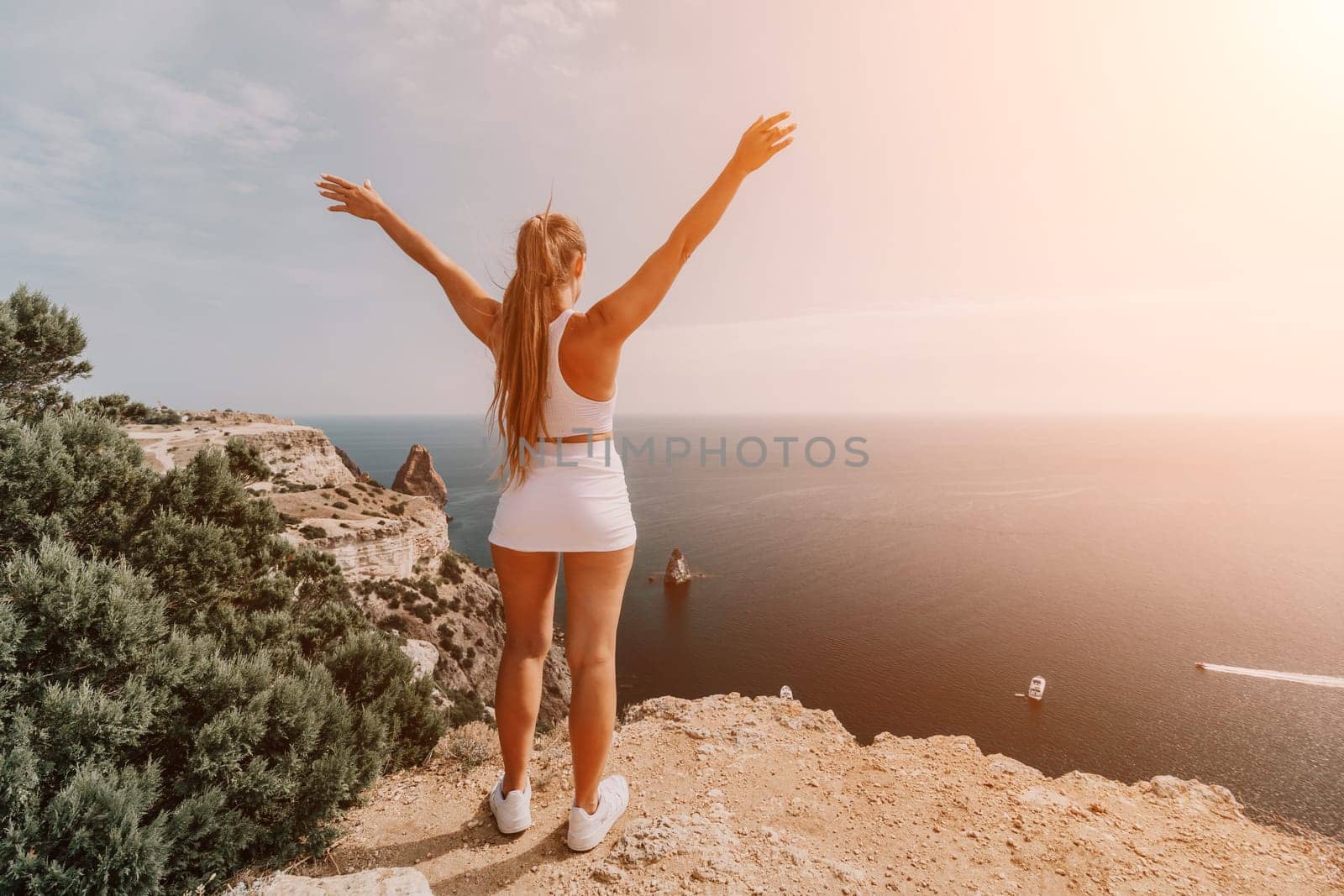 Middle aged well looking woman with black hair doing Pilates with the ring on the yoga mat near the sea on the pebble beach. Female fitness yoga concept. Healthy lifestyle, harmony and meditation.