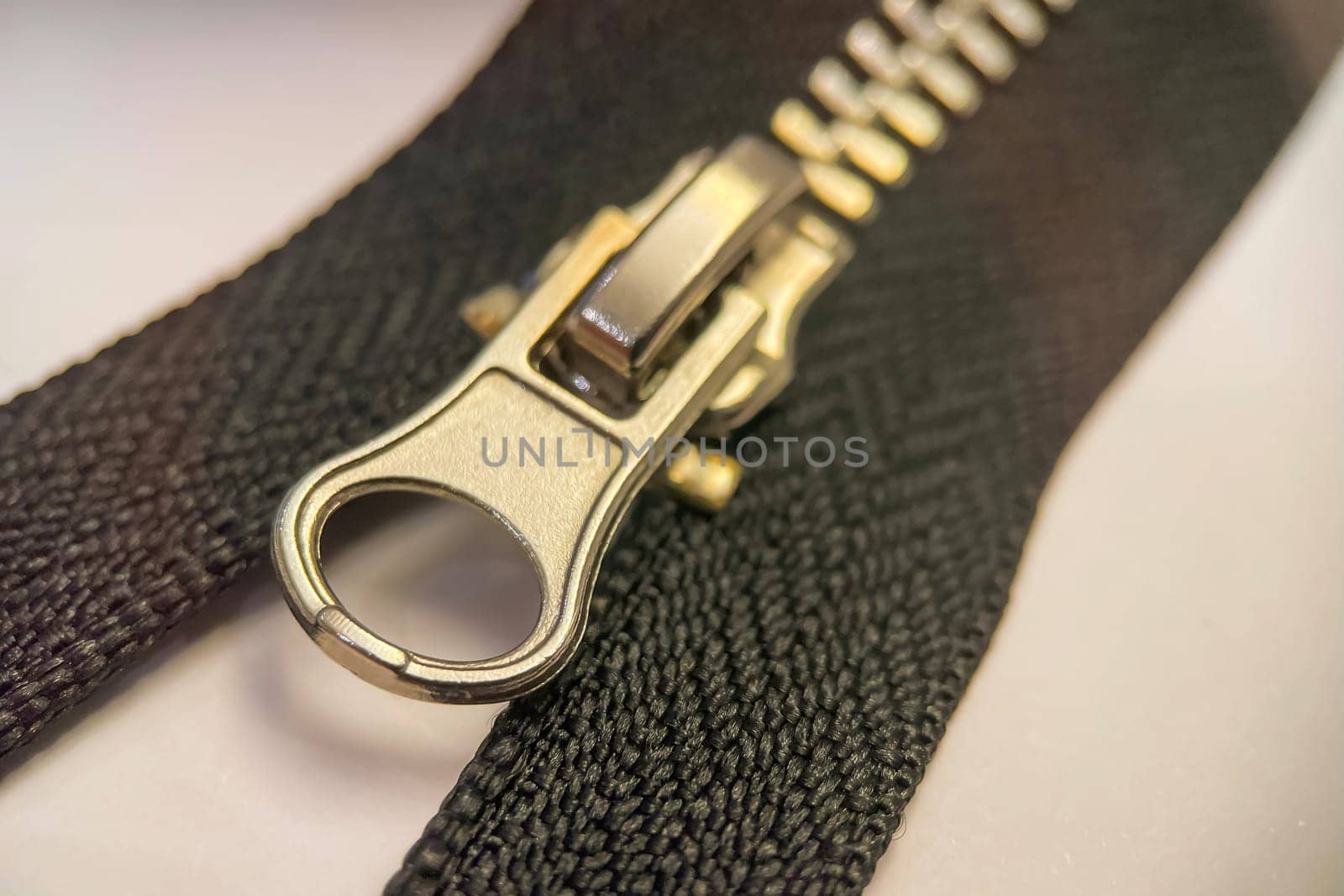 Zipper on a white background. Black zipper on white background, closeup of photo with selective focus. Close-up of zipper.Macro photo.