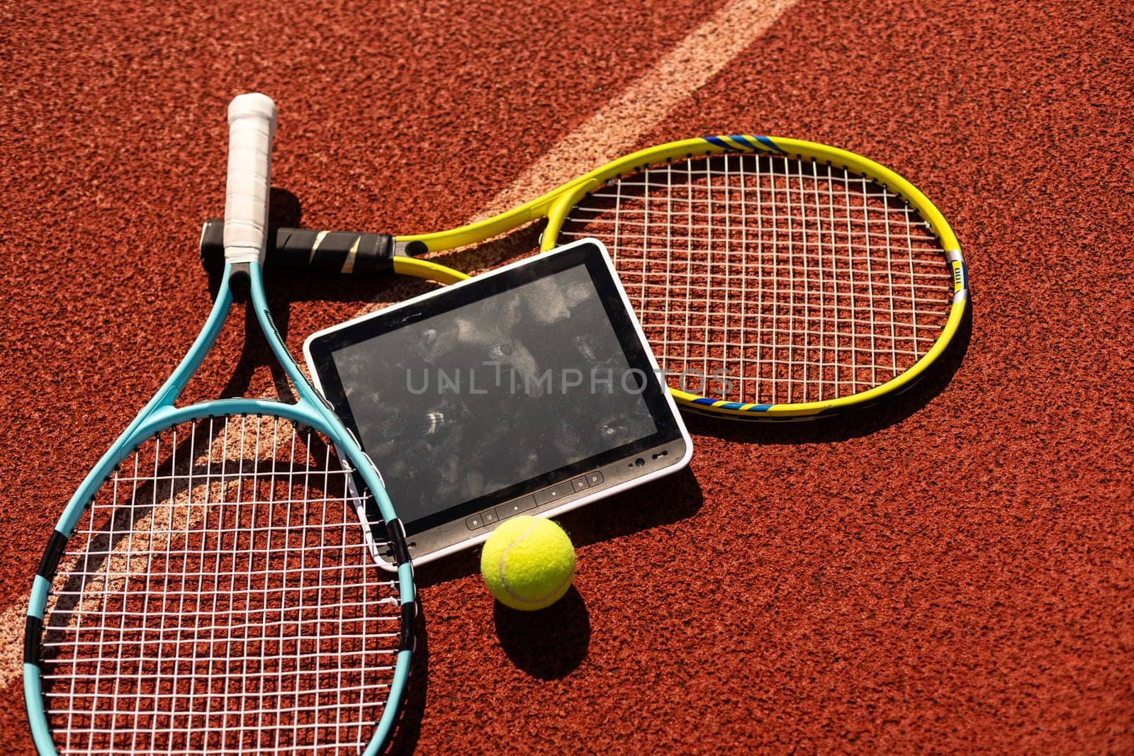 sport, fitness, technology, game and objects concept - close up of tennis racket with ball and tablet pc computer High quality photo