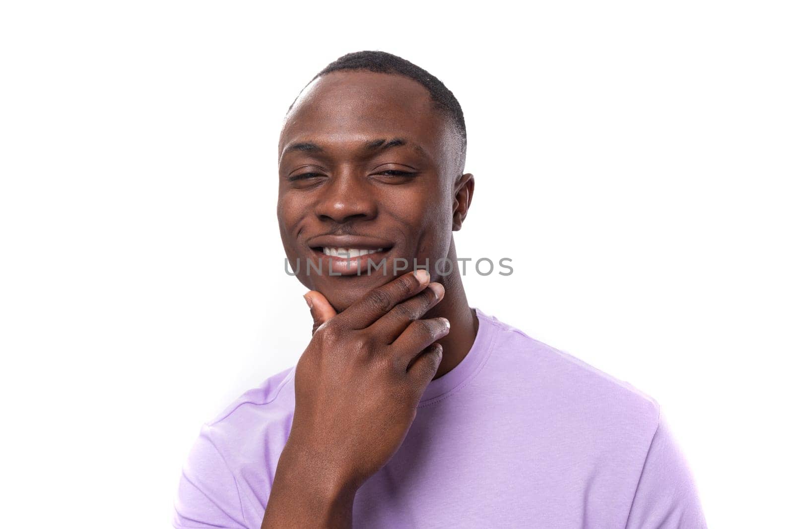 young serious well-groomed american guy dressed in a cotton t-shirt on a white background with copy space.