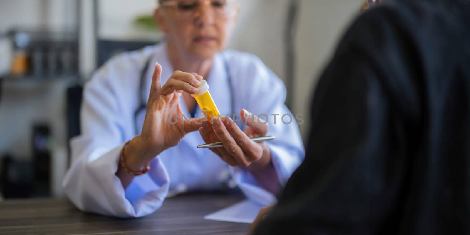 Medicine, healthcare and people concept female doctor with medicine bottle talking to women patient at hospital.