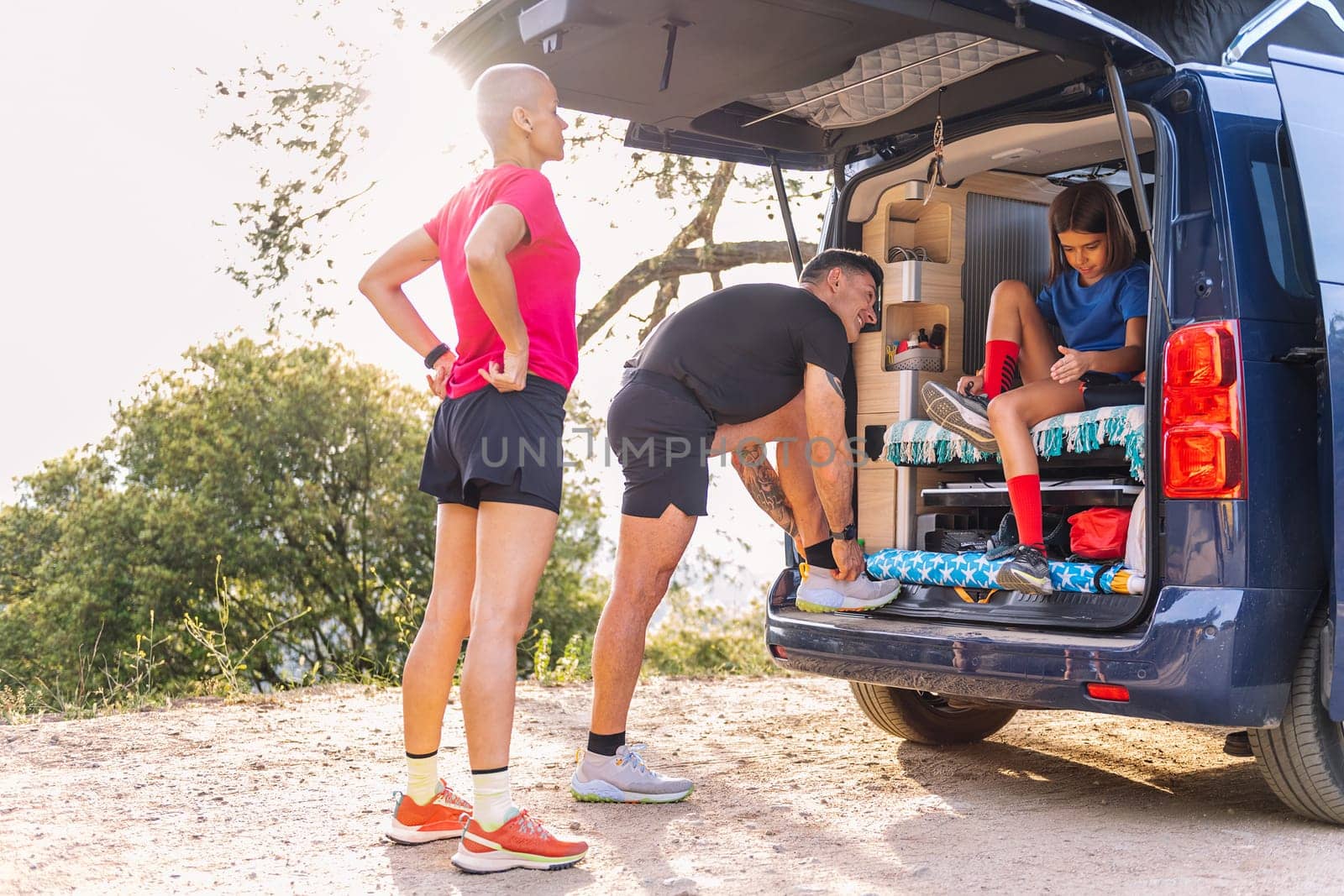 family in camper van preparing to trail running by raulmelldo