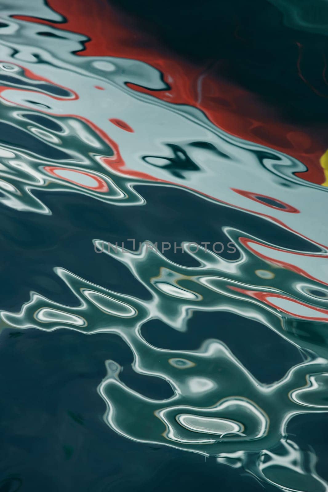 Abstract reflection of a moored yacht in the water of the bay, multicolored silhouette of reflection on the water surface, red blue and white color. High quality photo