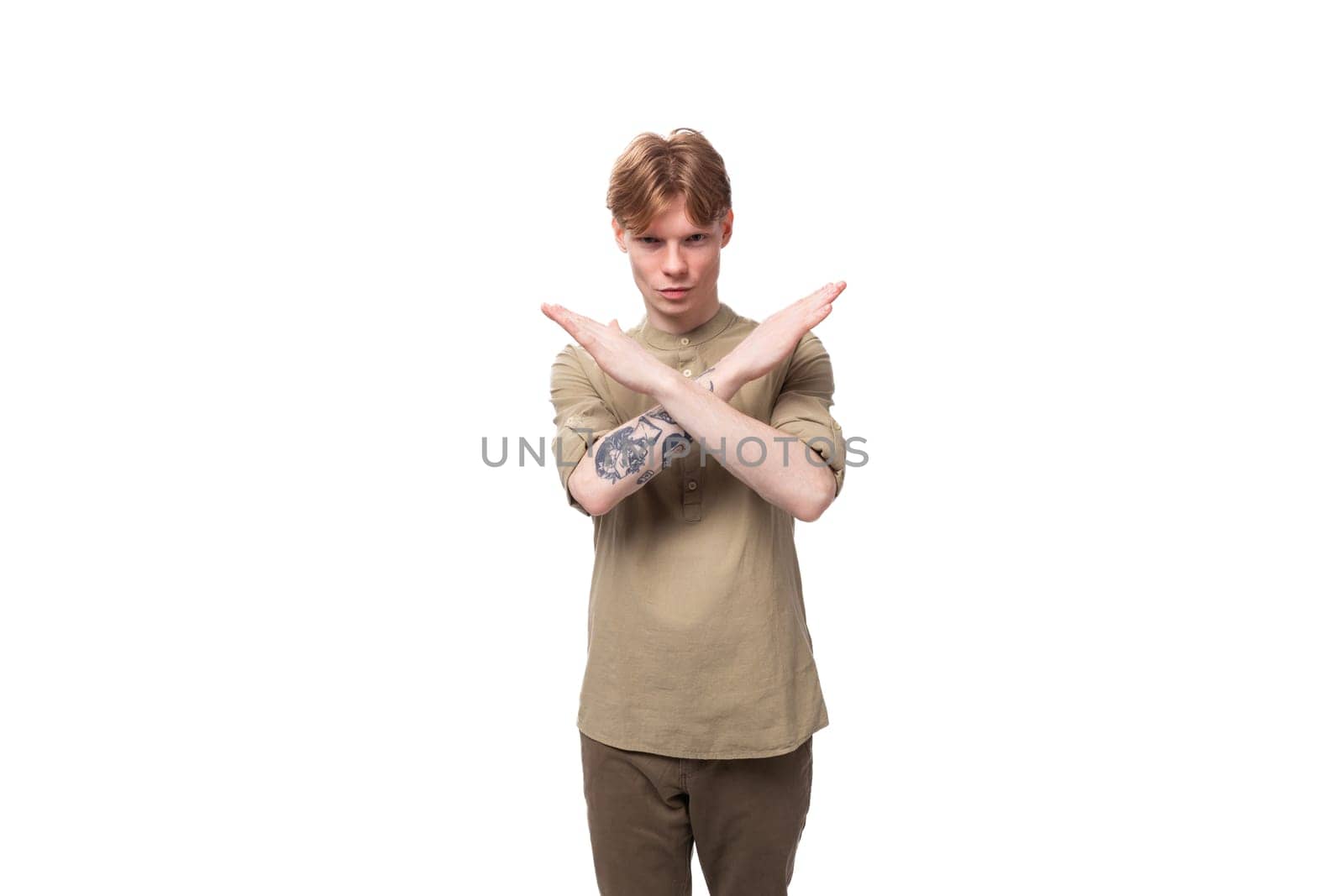 a young European man with red golden hair dressed in a light brown shirt gesticulates on a white background. advertising concept by TRMK