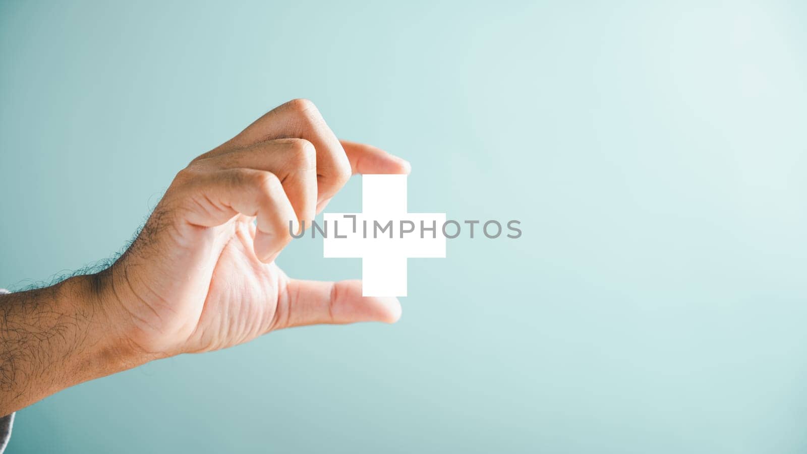 A hand holds a plus icon for medical care, signifying advantages. Health insurance health concept featuring access to welfare health and spacious copy area.