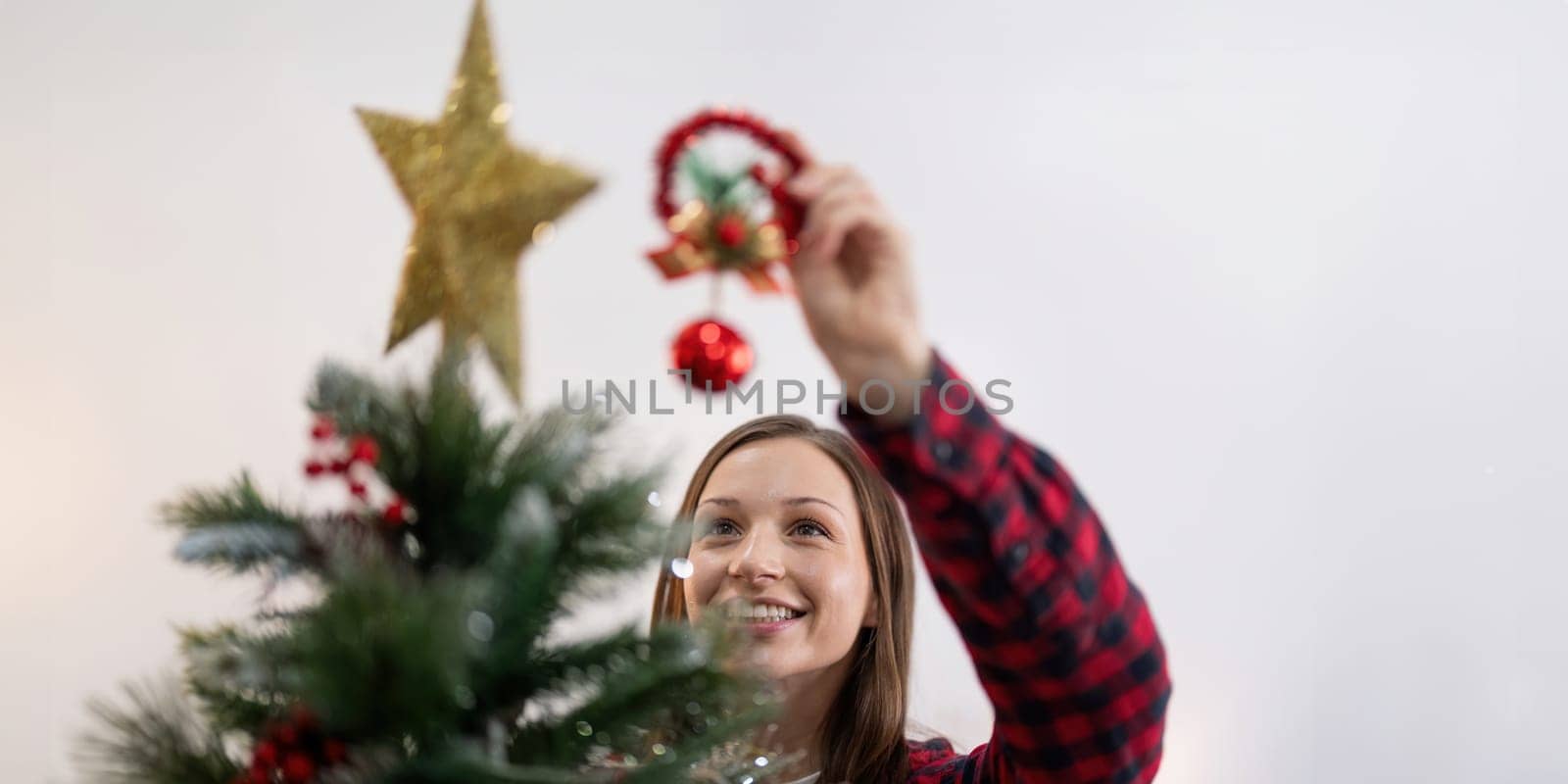 Cheerful woman decorate the christmas tree. Christmas atmosphere at cozy home interior.