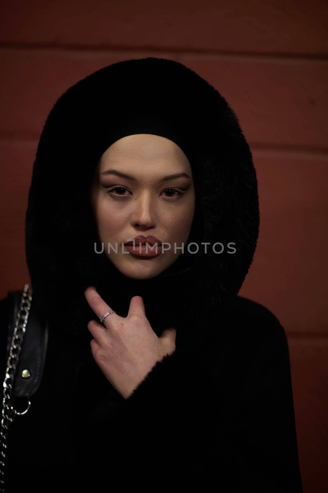 Muslim woman walking on urban city street on a cold winter night wearing hijab by dotshock