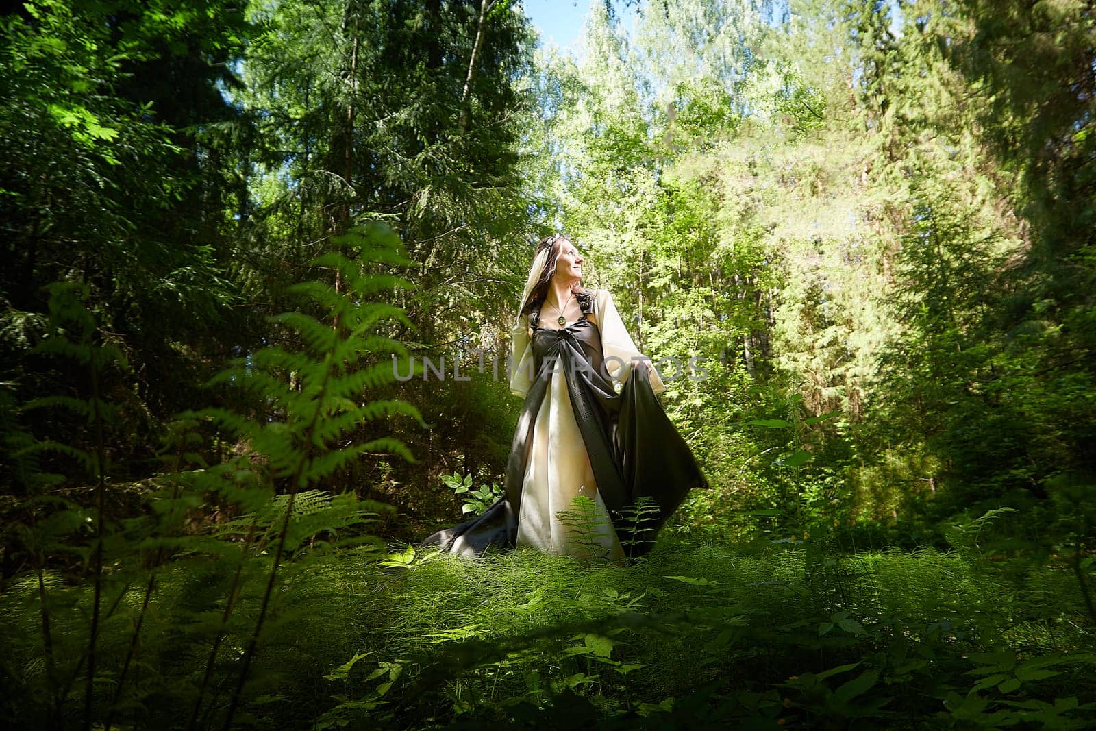 Beautiful seductive dryad. Pagan spirit of forest. Portrait of beautiful dryad. Fairy who loves nature in beautiful green summer forest. Concept of environmental friendliness and caring for nature