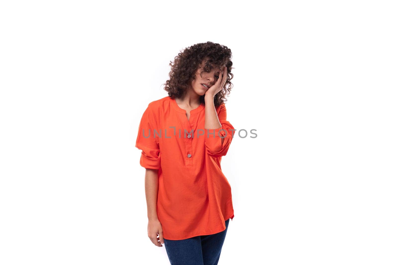 young tired caucasian lady with black curly hair dressed in an orange shirt thought.