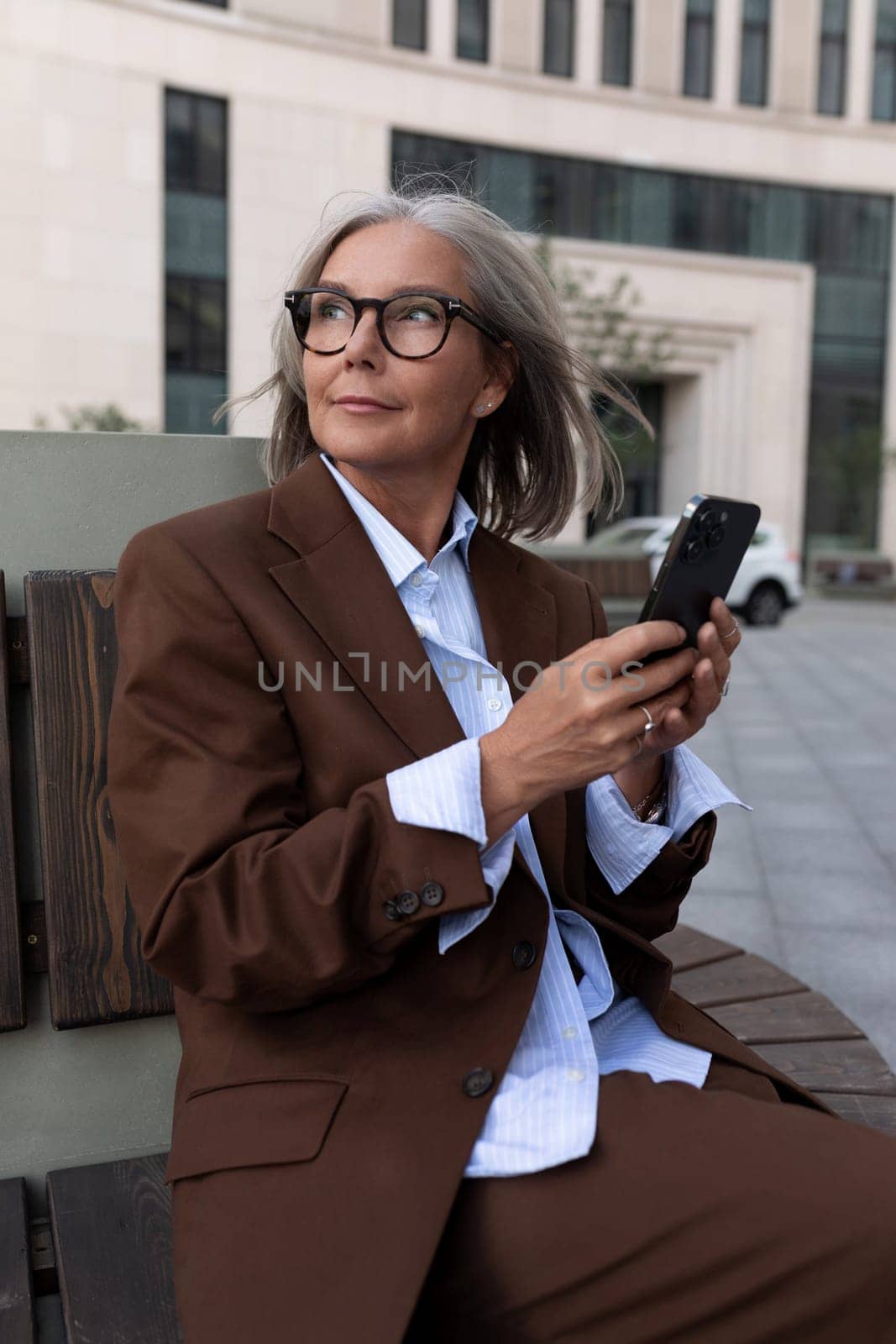 portrait of a well-groomed charming entrepreneur woman of mature years in a brown suit.