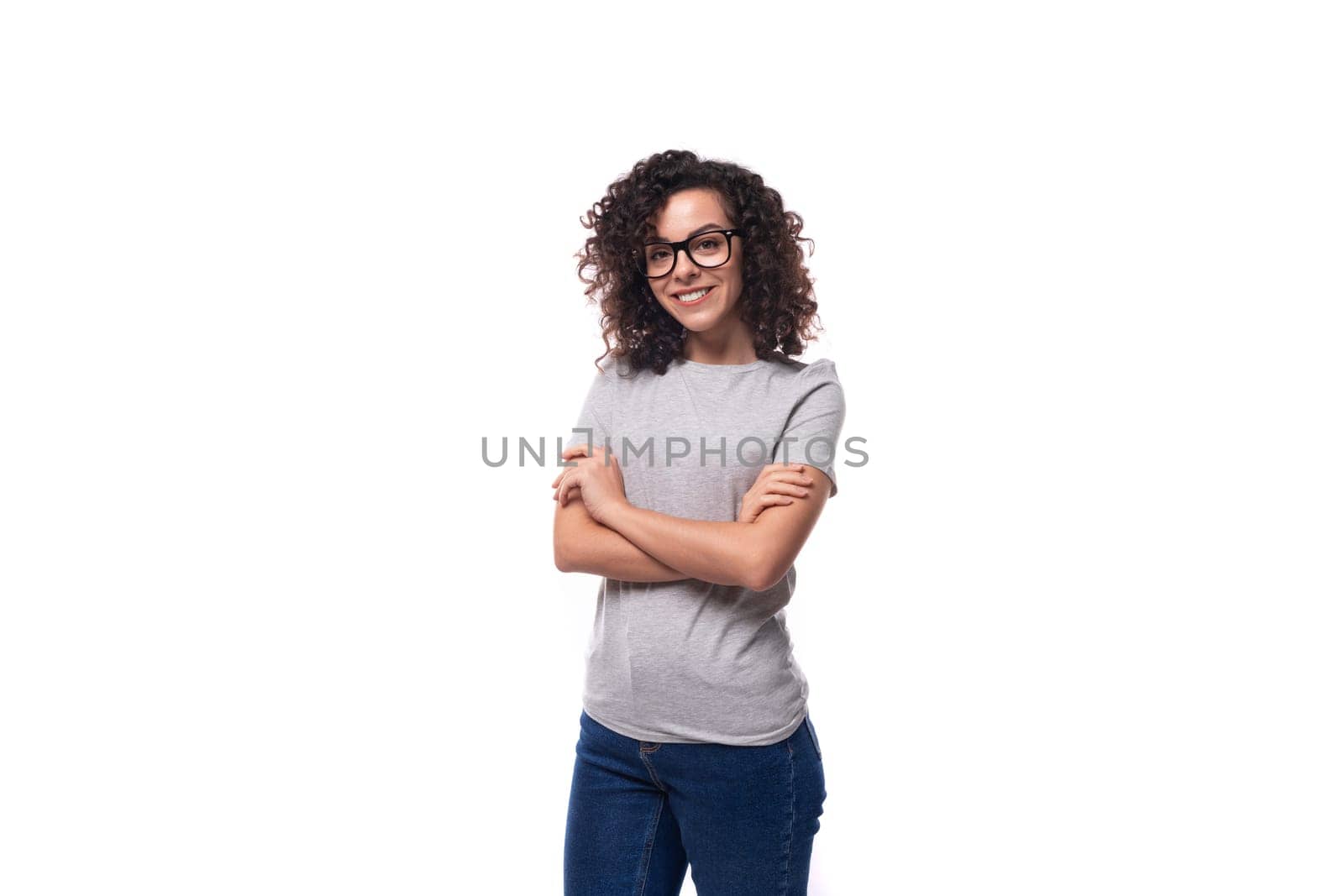 beautiful european woman with black curly hair wears eyeglasses on a white background with copy space.