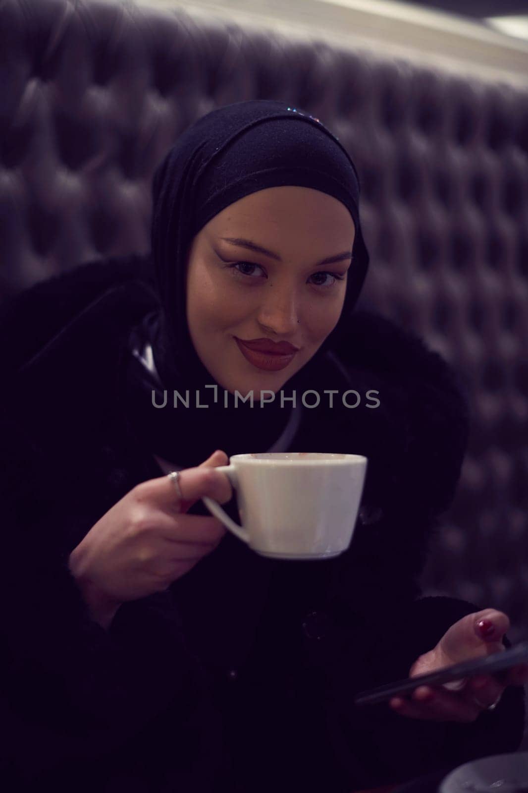 happy Middle Eastern female having break take a cup of tea in restaurant by dotshock