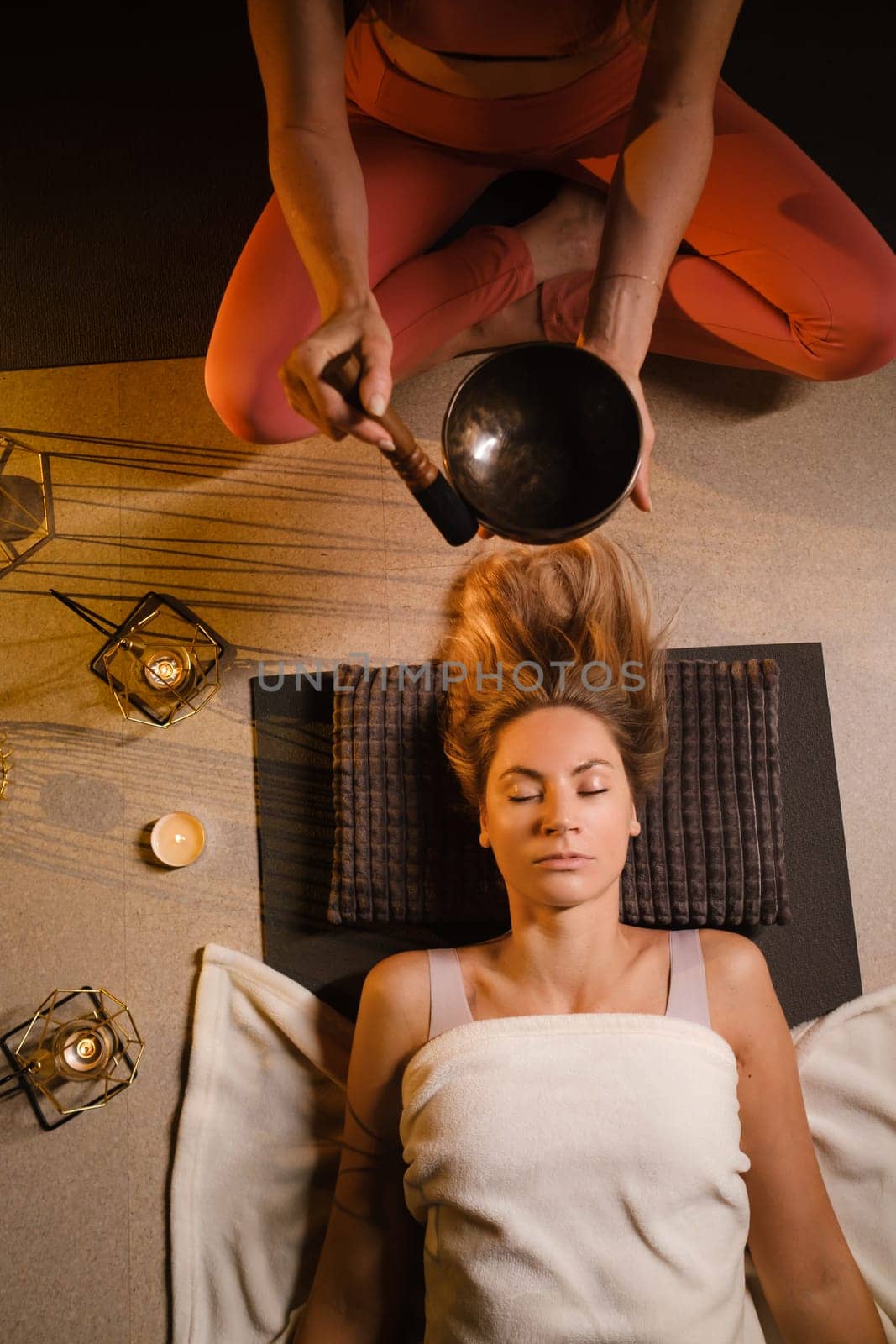 a girl lying on the floor relaxes to the sounds of a Tibetan bowl in the gym by Lobachad