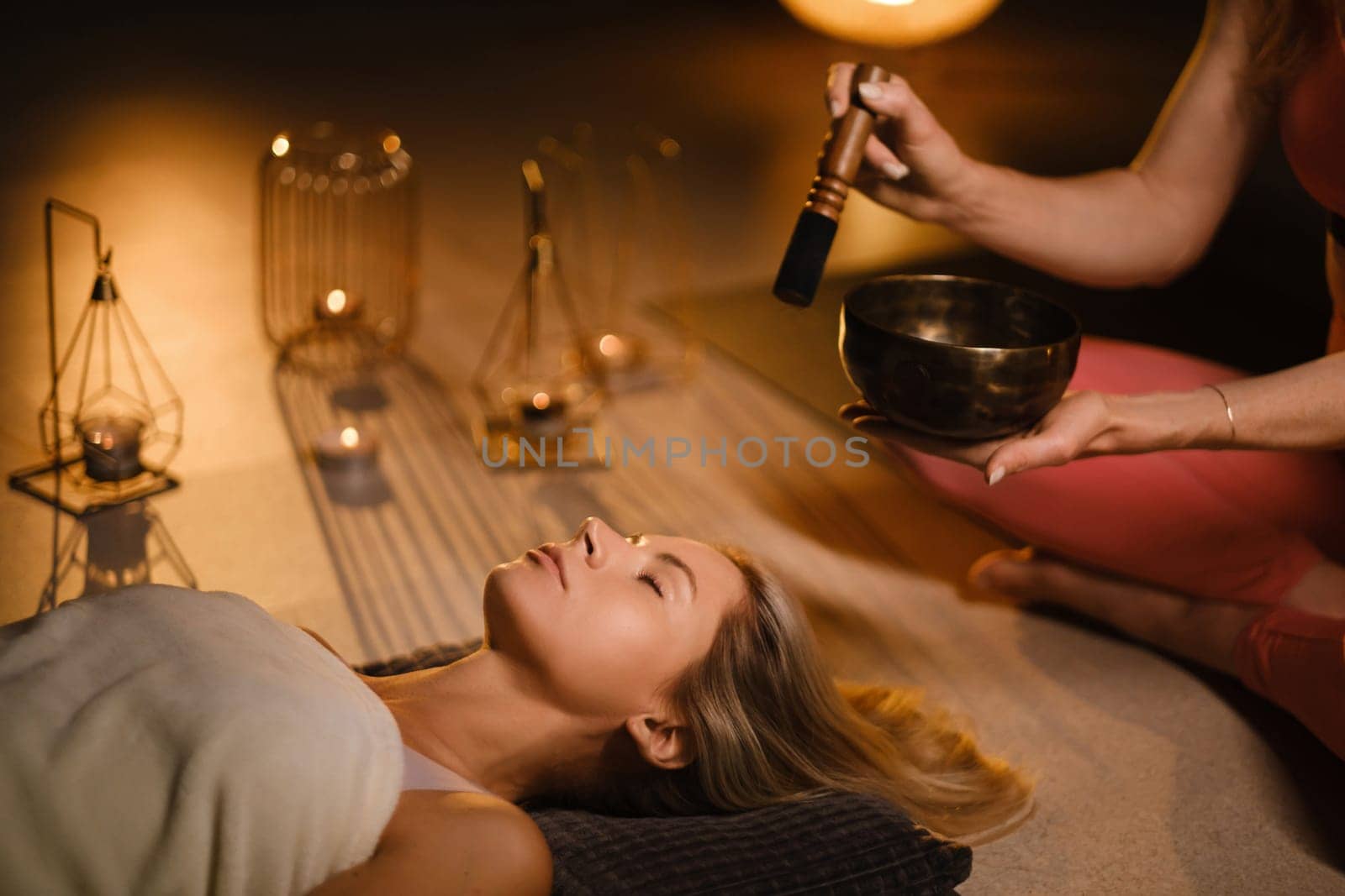 a girl lying on the floor relaxes to the sounds of a Tibetan bowl in the gym by Lobachad