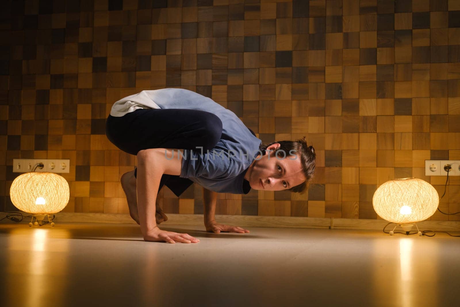 a man with a naked torso does yoga in the gym. the concept of a healthy lifestyle by Lobachad