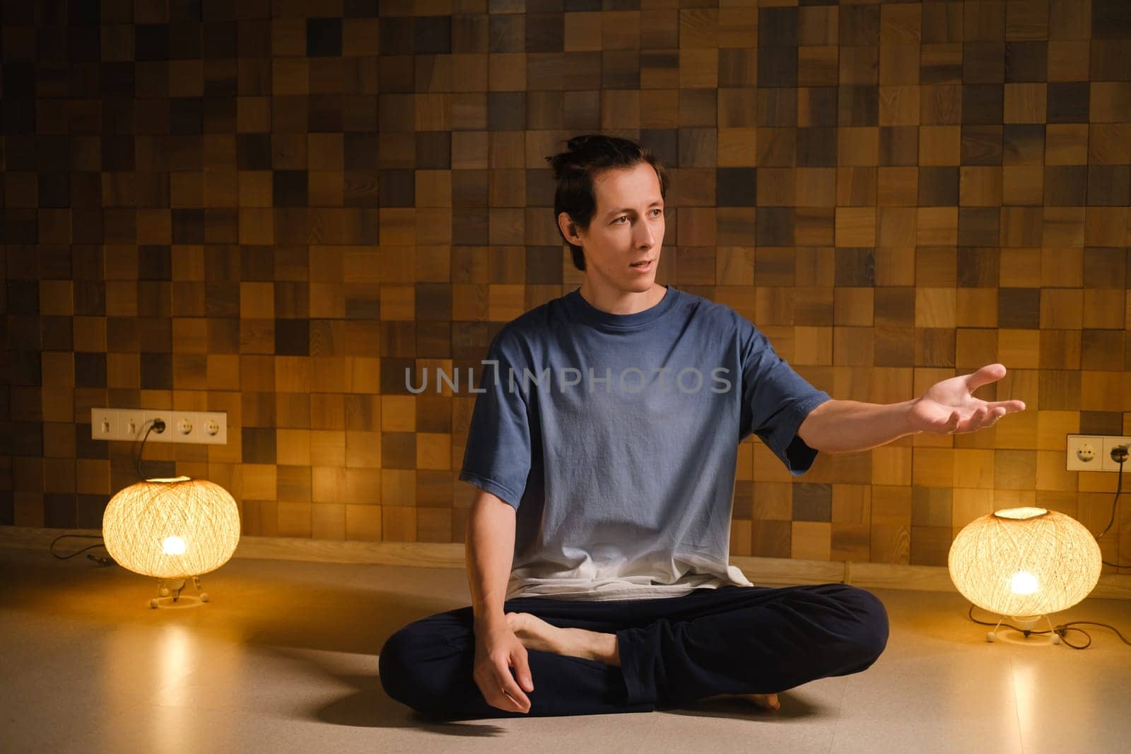 a man in a sports uniform does yoga in a fitness room. the concept of a healthy lifestyle by Lobachad