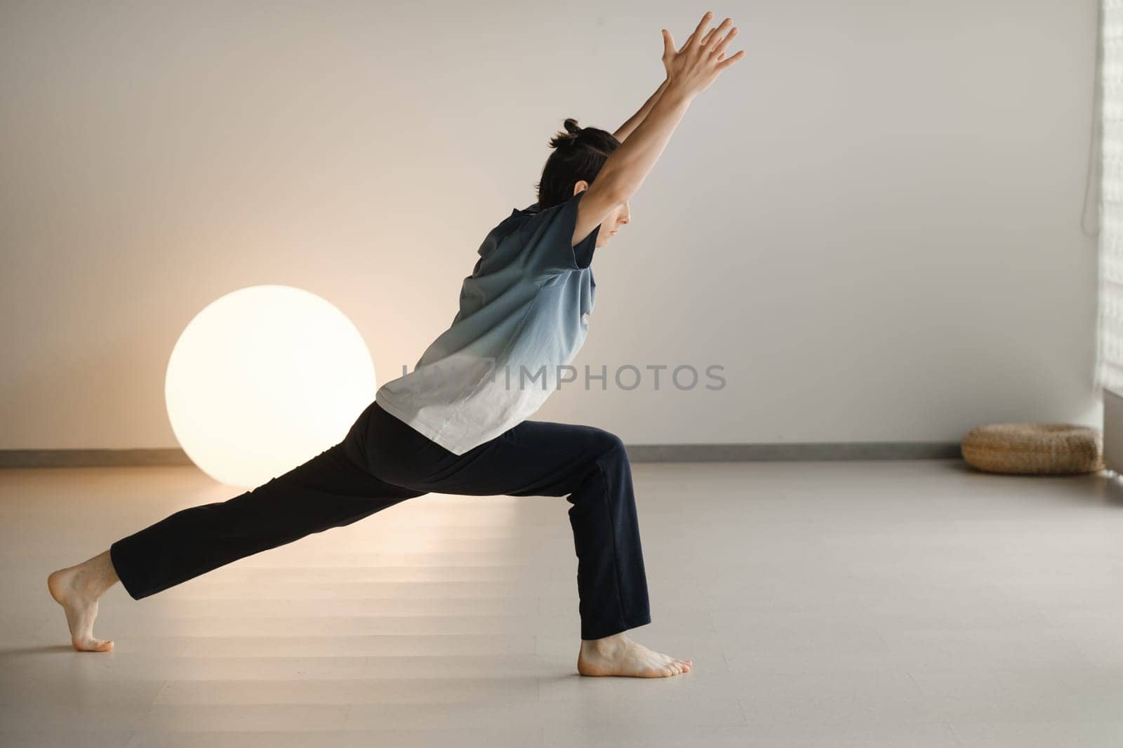 a man in a sports uniform does yoga in a fitness room. the concept of a healthy lifestyle by Lobachad