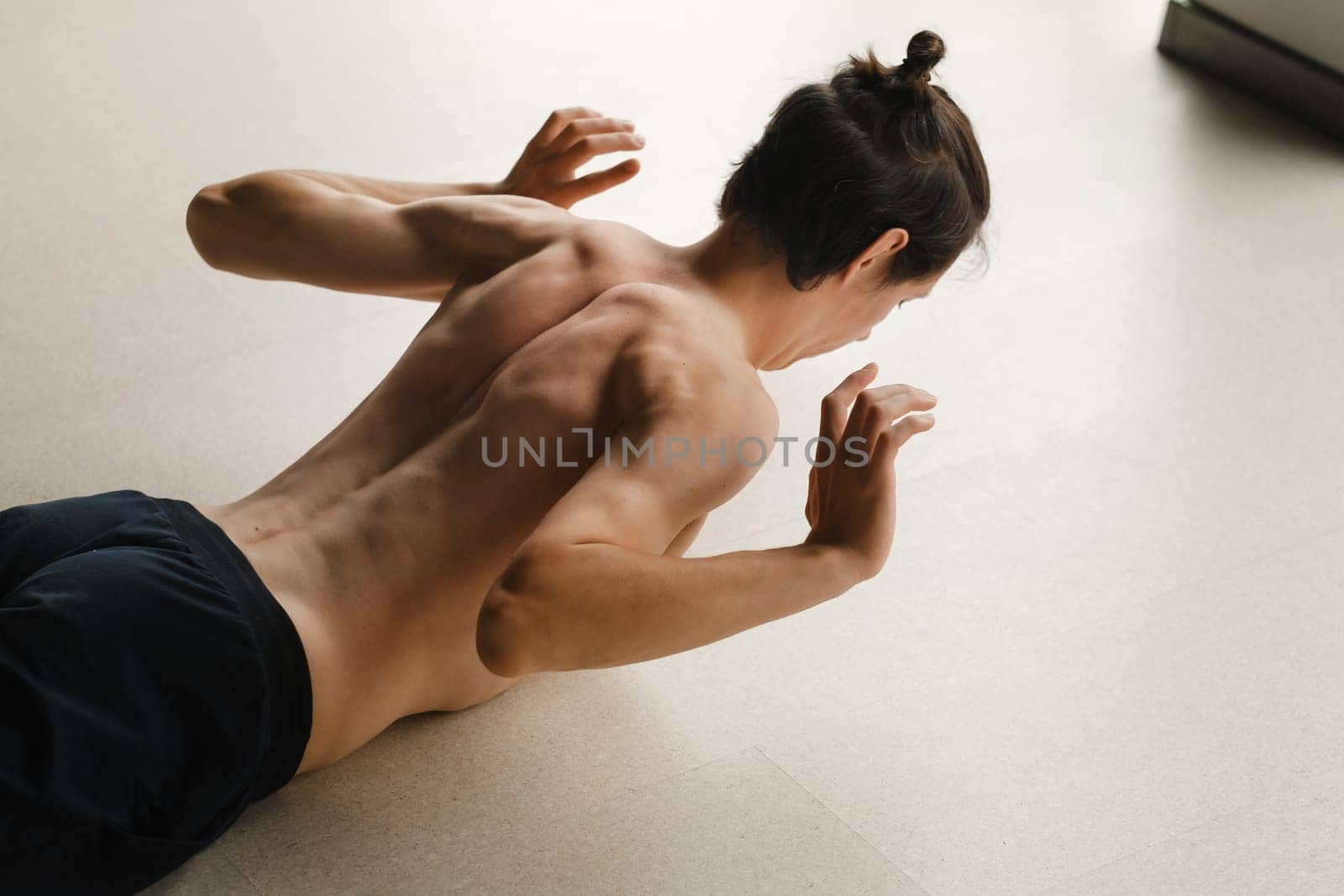 a man with a naked torso does yoga in the gym. the concept of a healthy lifestyle.