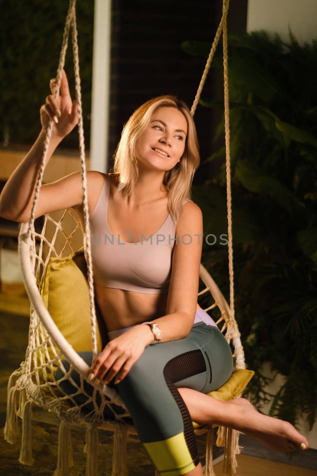 A young woman is resting in a chair after a sports workout and yoga class.