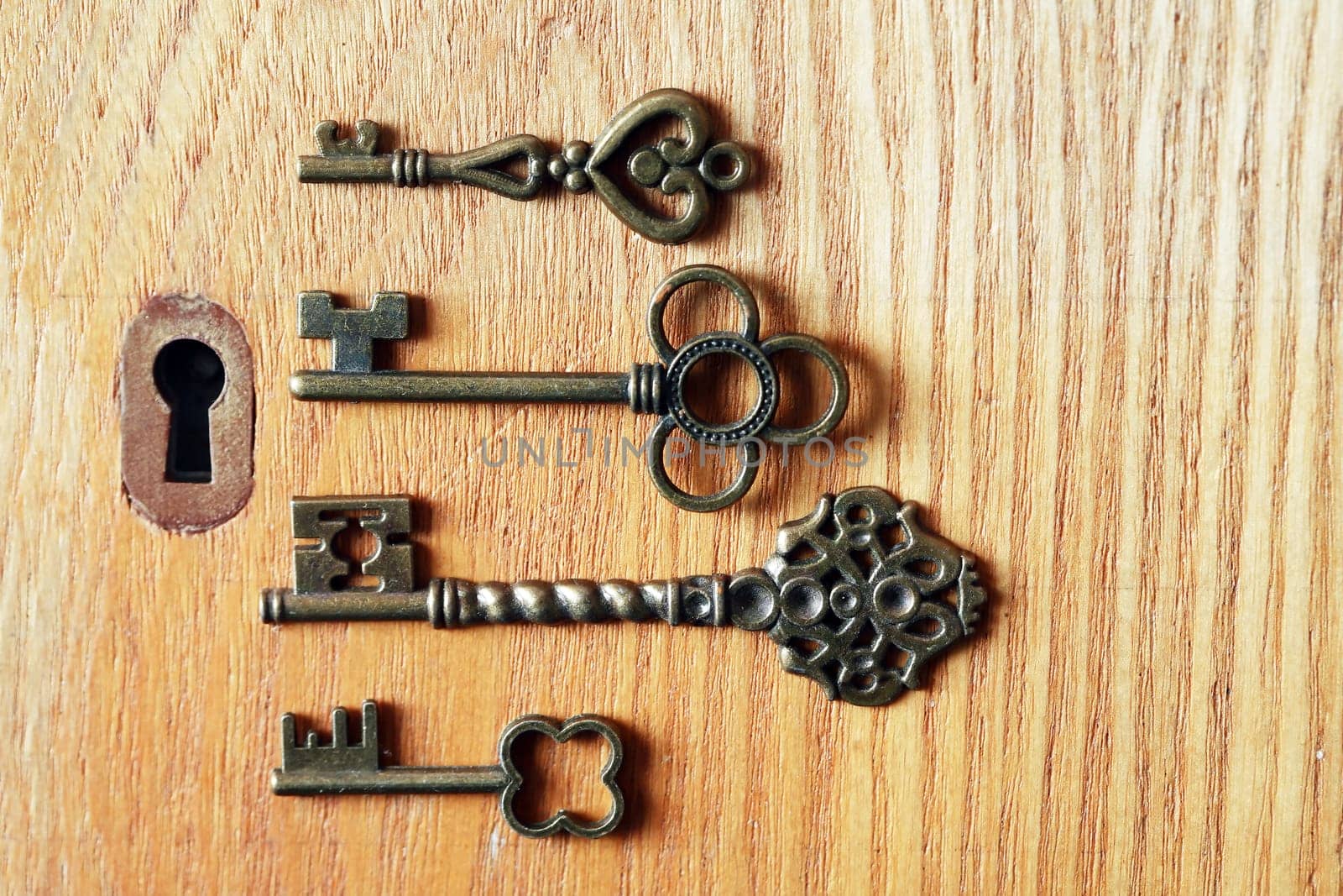 Set of various old keys closeup near keyhole