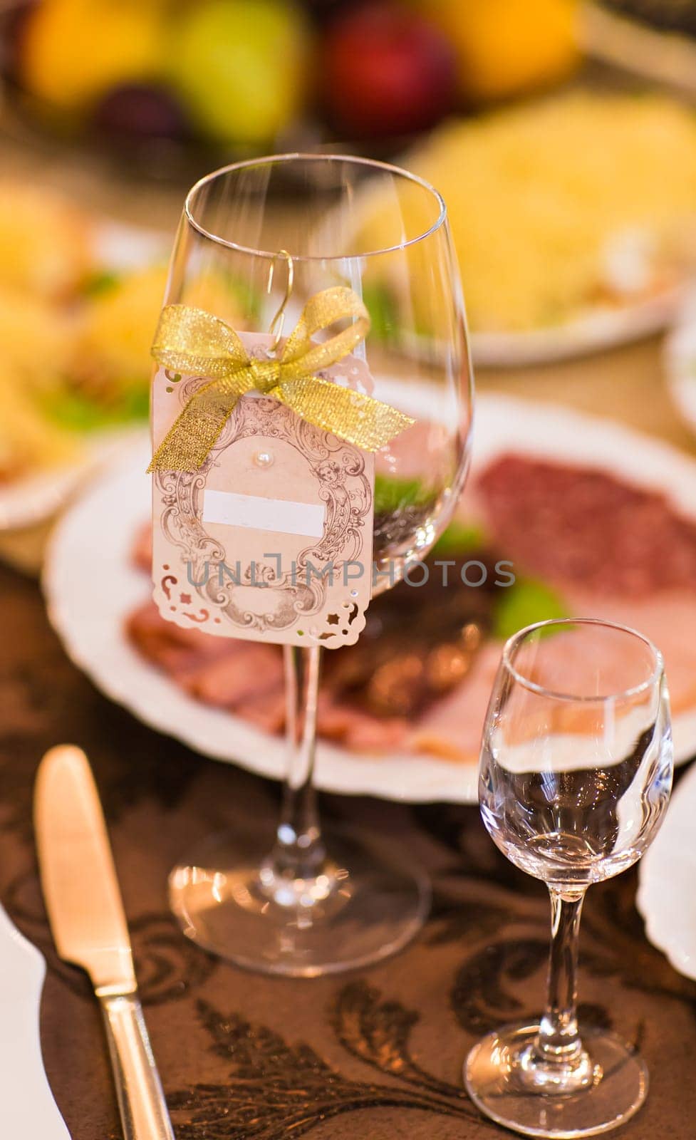 Close-up of wine glass and name card on festive table by Satura86