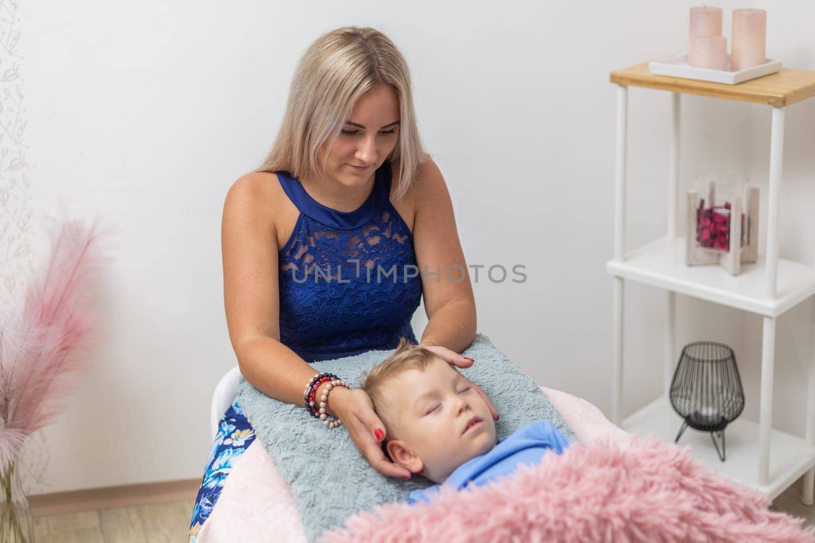 Process of access or consciousness bars therapy, woman healing an young boy by method of 32 points on the head that we touch lightly in certain combinations, alternative medicine