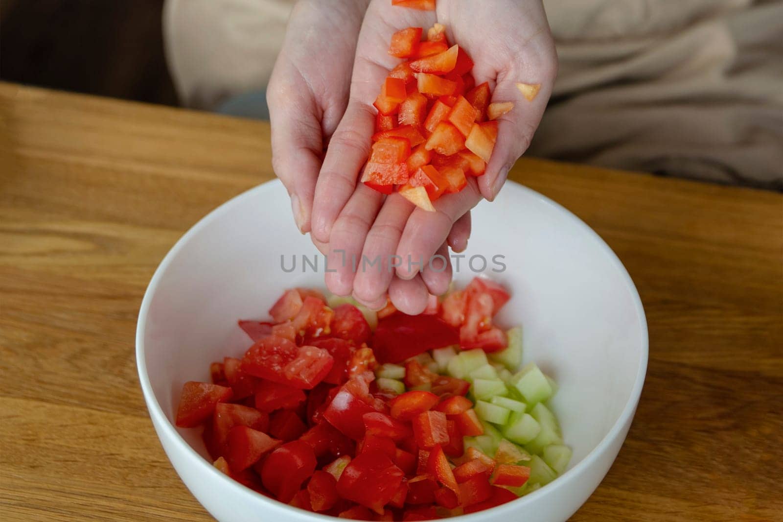 A woman's hands sprinkles small pieces of paprika close-up. Prepare salad as a side dish for the main dish. High quality photo