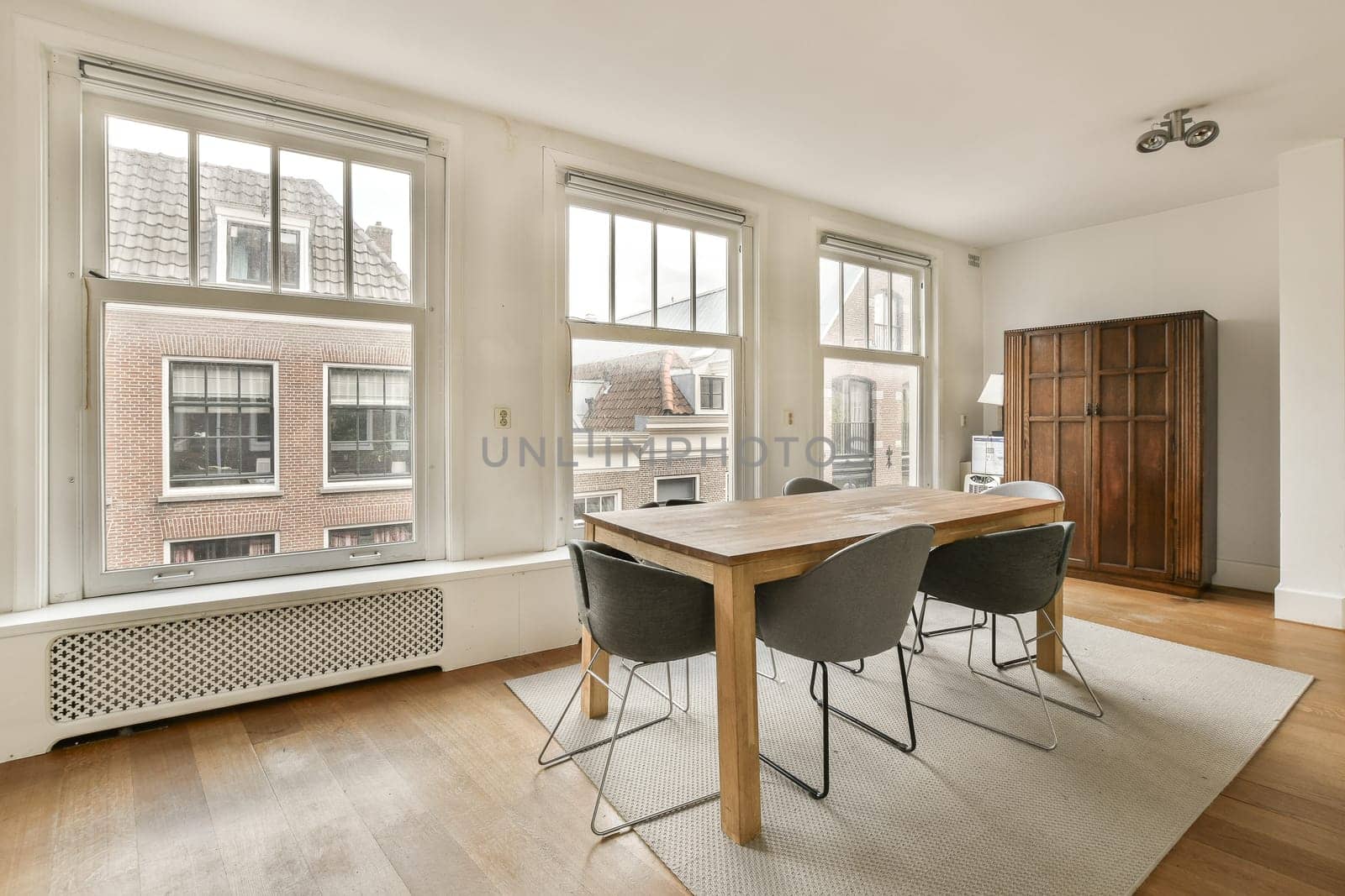 a dining room with a large window and a table by casamedia