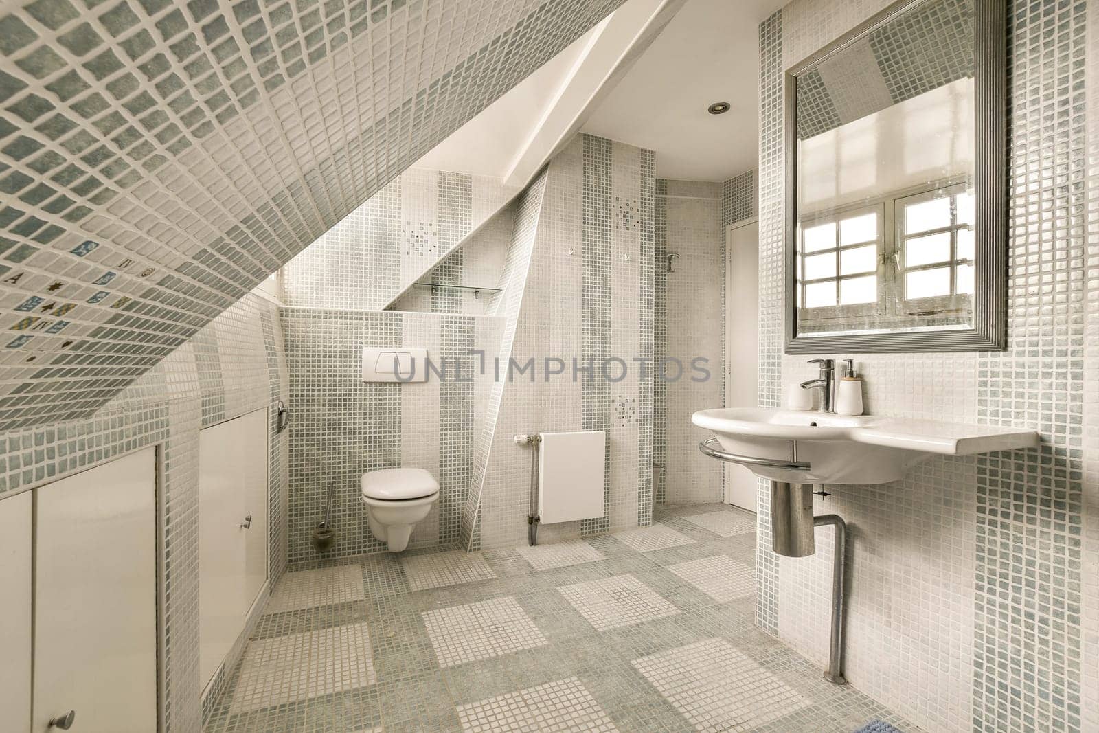 a bathroom with blue and white mosaic tiles on the walls, along with a sink and toilet in the corner