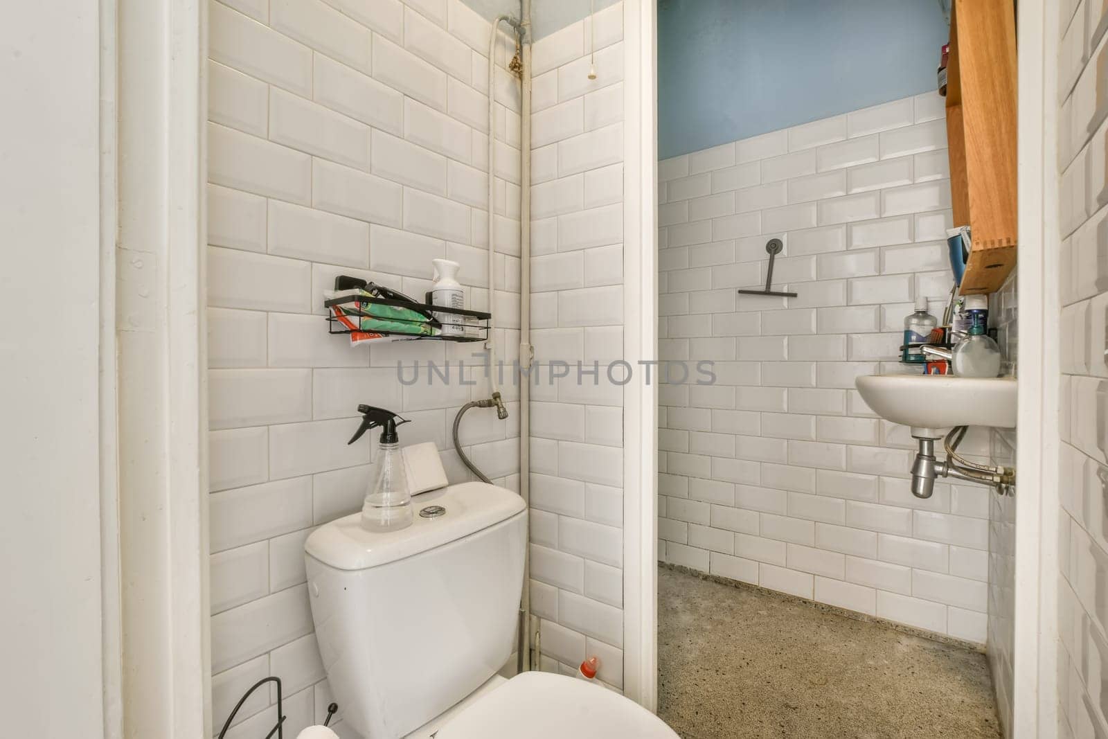 a white bathroom with a toilet and a sink by casamedia