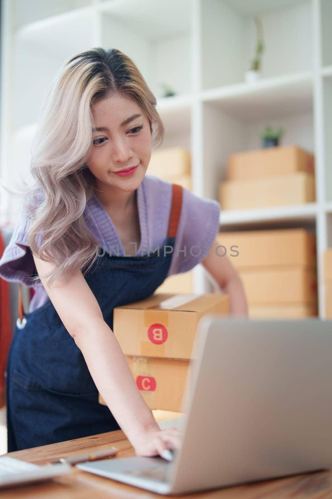 Asian female business owner handles delivery of orders to customers by Manastrong